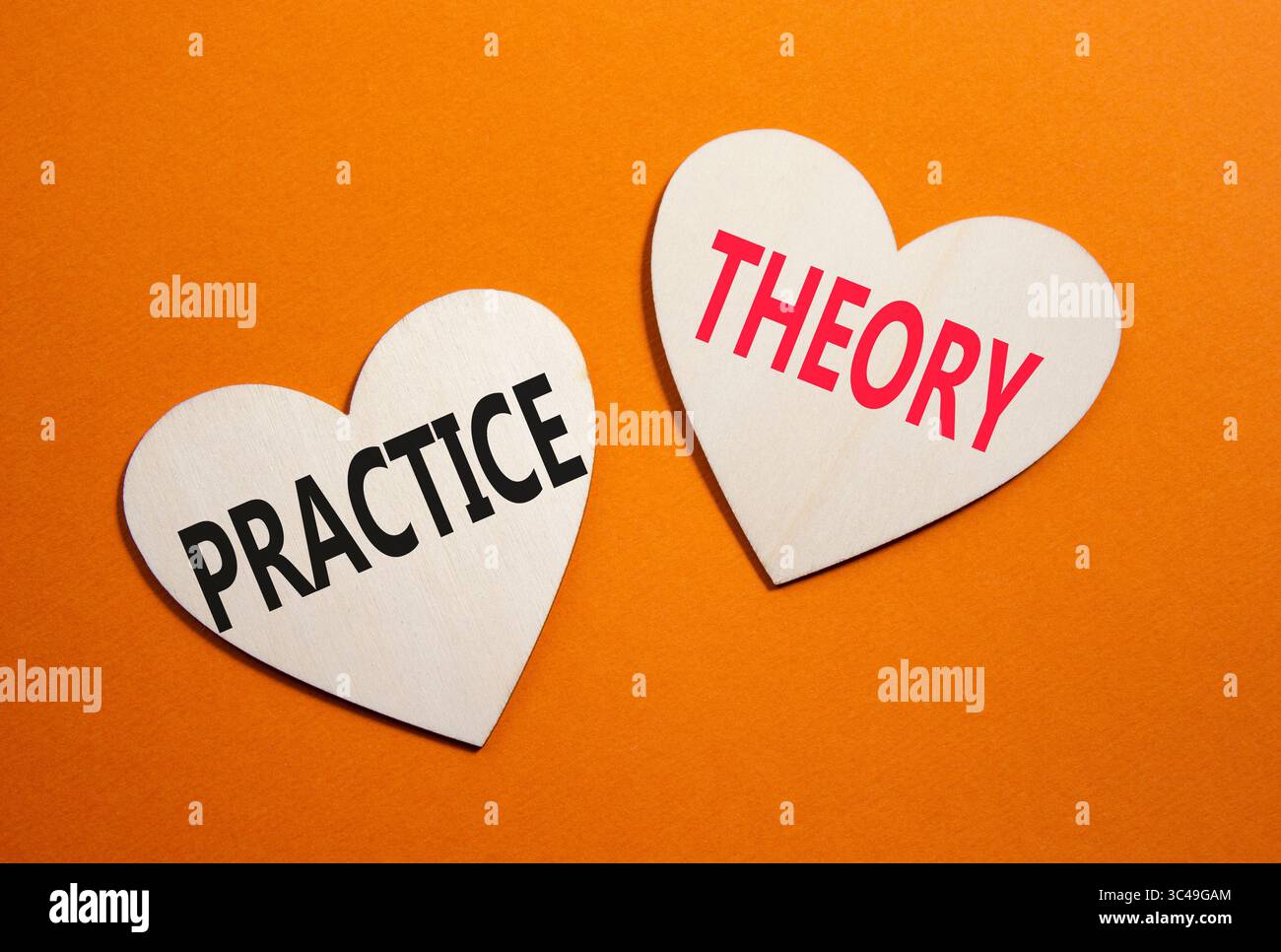 Theorie- oder Praxissymbol. Konzeptwort Theorie oder Praxis auf hölzernen Herzen. Wunderschöner orangefarbener Hintergrund. Business and Theory oder Practice Concept. Cop Stockfoto