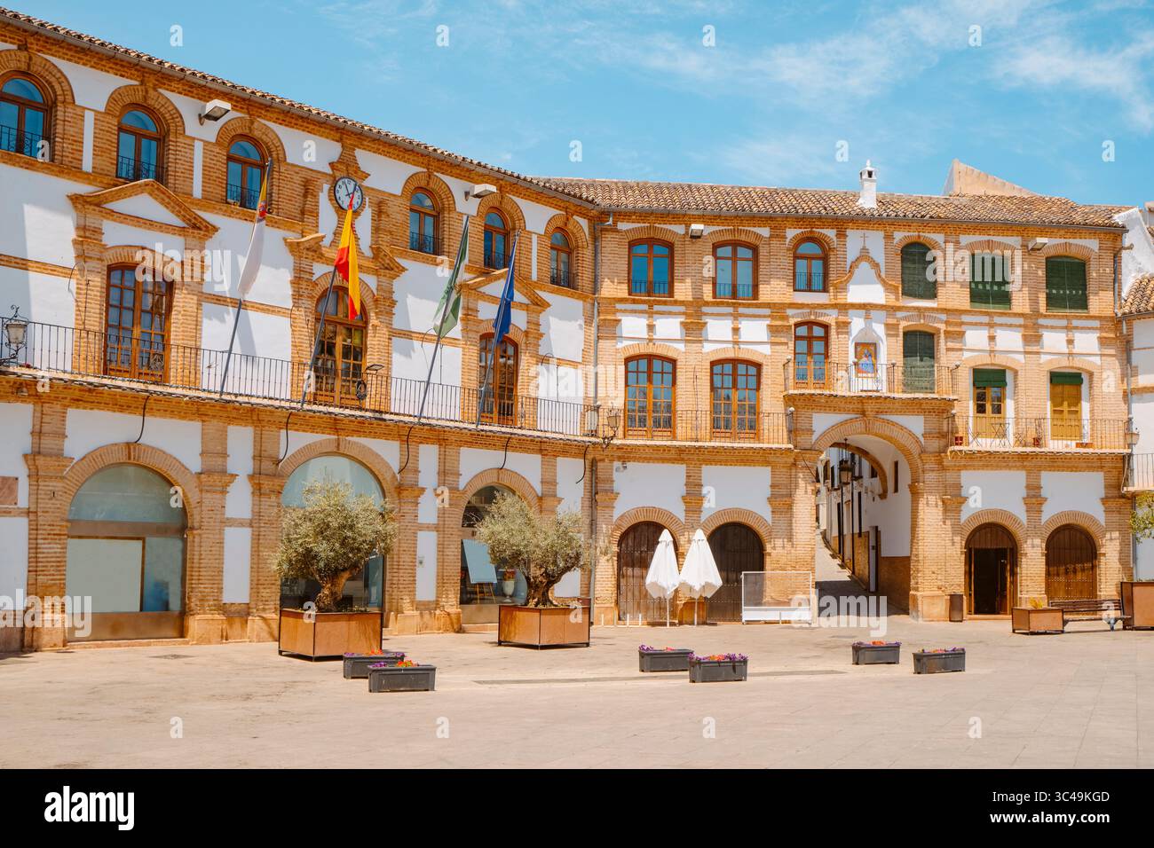 Das Rathaus von Archidona, Spanien, auf der linken Seite mit einer Uhr im oberen Teil seiner Fassade, auf der schönen barocken Plaza Ochavada, auf einem Su Stockfoto
