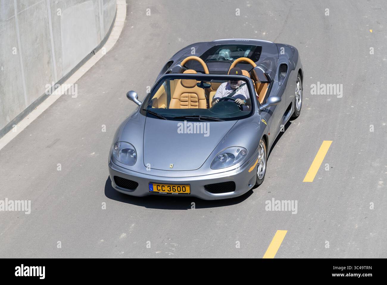 Wickrange, Luxemburg - Blick auf einen grauen Ferrari 360 Modena Spider, der auf einer Straße fährt, von oben gesehen. Stockfoto