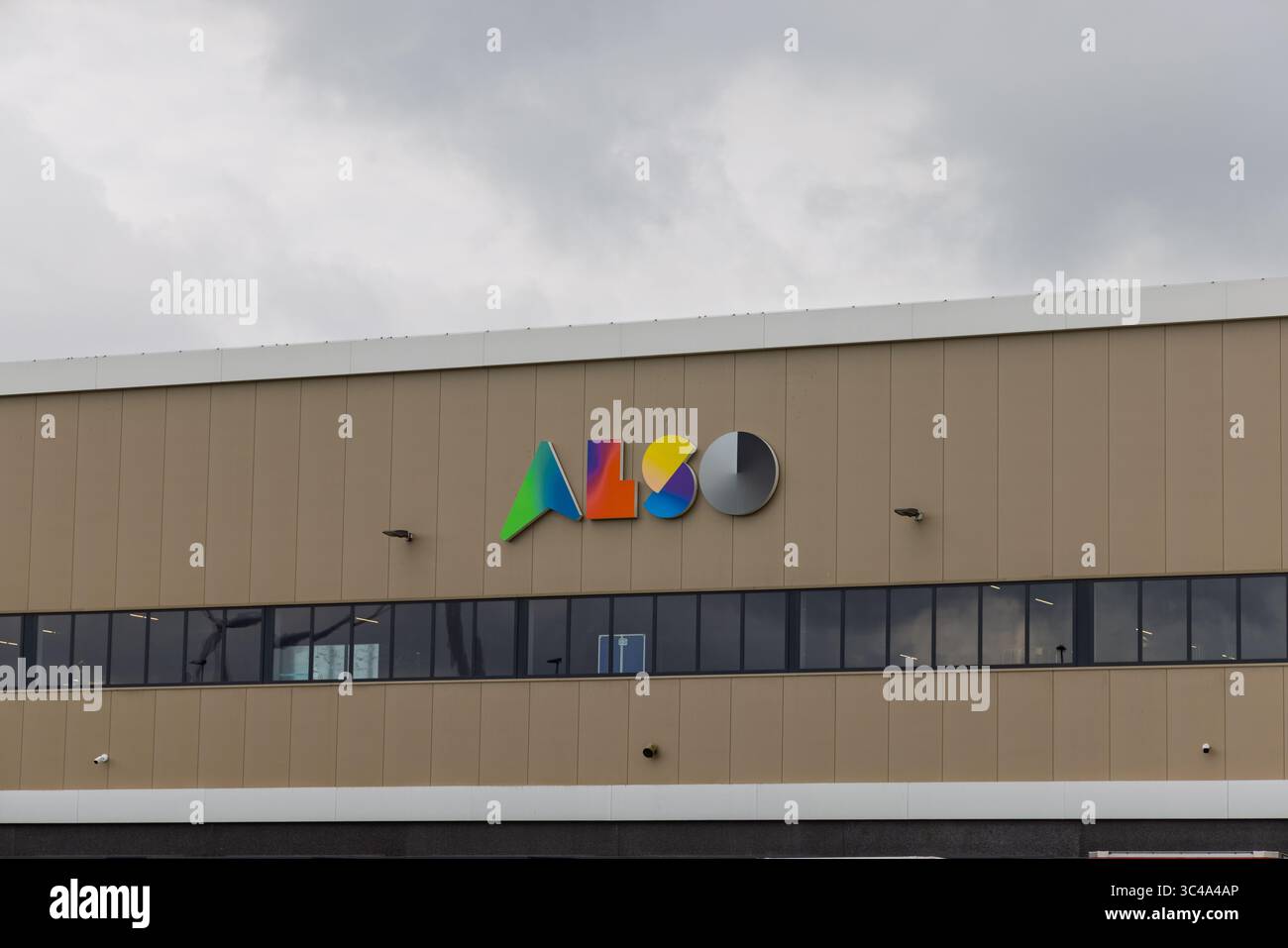 Eine Nahaufnahme des „AUCH“-Logos an der Seite eines modernen Gebäudes. Die Buchstaben weisen einen Farbverlauf von Grün zu Blau und Gelb auf. Stockfoto