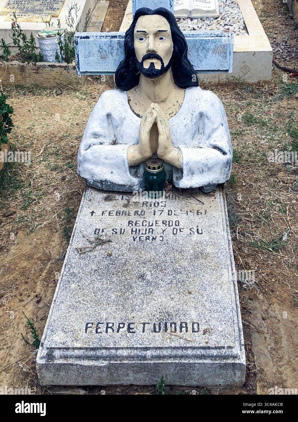 Das einzigartige Grab in Oaxaca, Mexiko, zeigt eine eindrucksvolle Skulptur von Jesus im Gebet, Hände verbunden und Augen breit, auf einem traditionellen Steingrab. Stockfoto