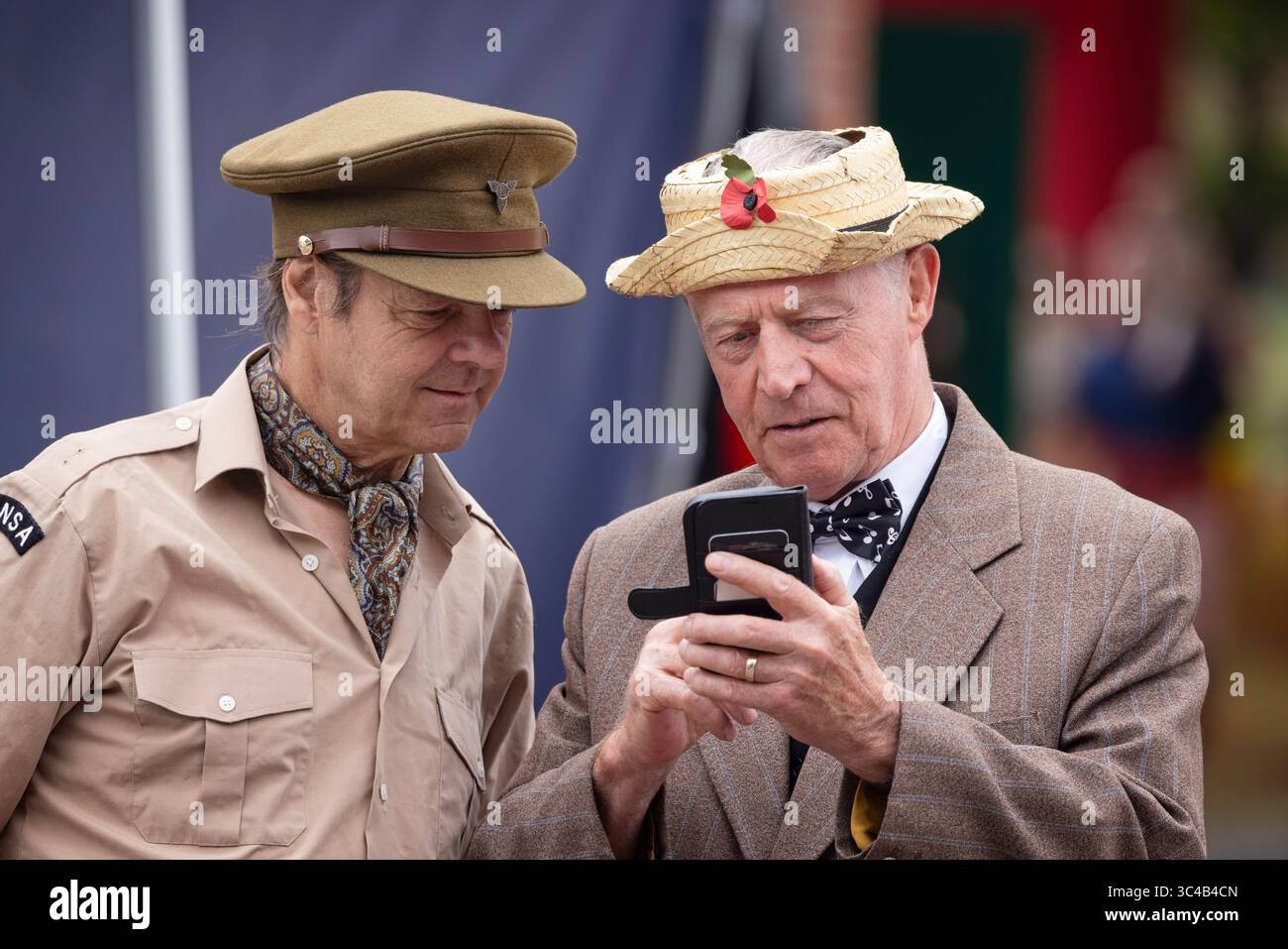Hommage an Bud Flanagan Schauspieler mit Handy und Schauspieler in WWII ENSA Uniform beim 80. Jahrestag des Zweiten Weltkriegs im Warminster Park, Wiltshire, Großbritannien. Stockfoto