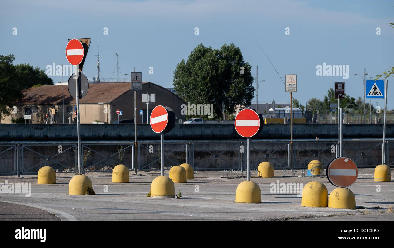 Mehrere Verkehrsverbotsschilder mit gelben Barrieren auf der Straße Stockfoto