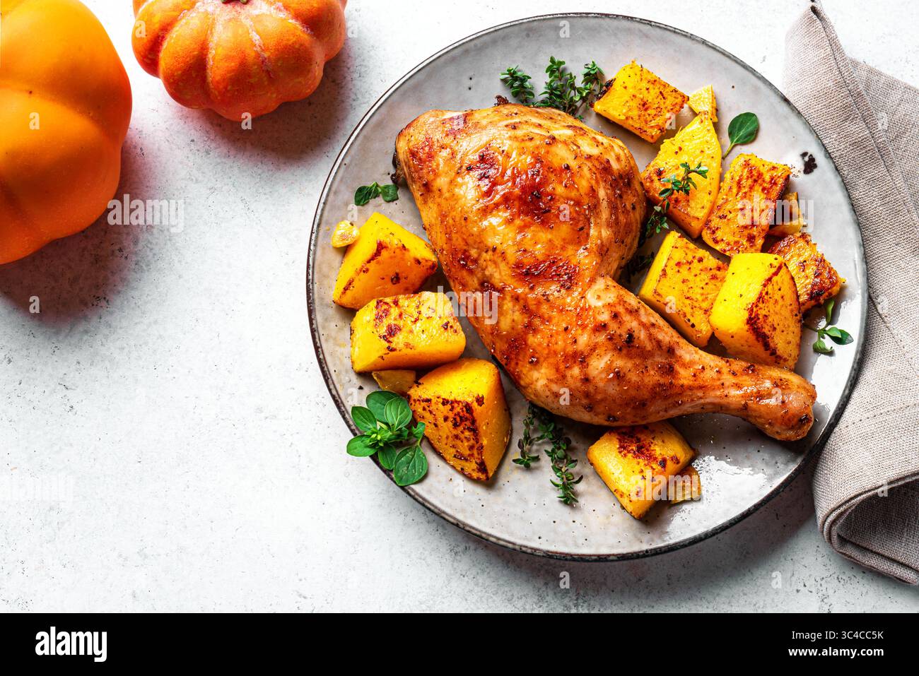 Gebratenes Hähnchenviertel und Kürbis mit Knoblauch und Kräutern aus nächster Nähe. Im Ofen gebackener Kürbis und truthahn, saisonales Herbstgericht. Stockfoto