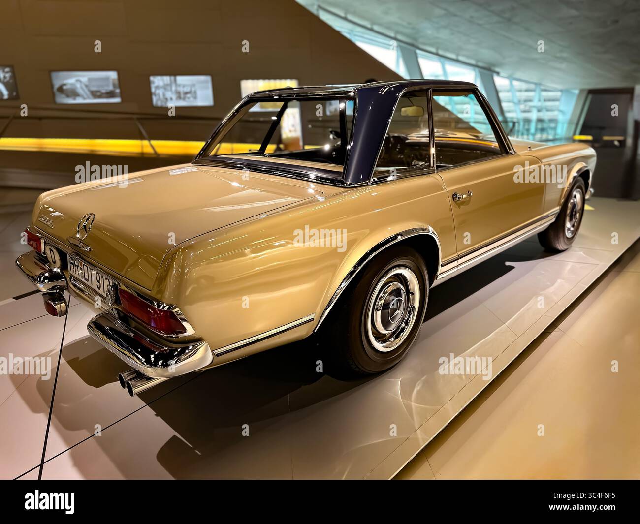 Klassisches goldenes Mercedes-Benz SL Pagoda Coupé mit schwarzem Hardtop, Rückansicht, in eleganter Beleuchtung. Stockfoto