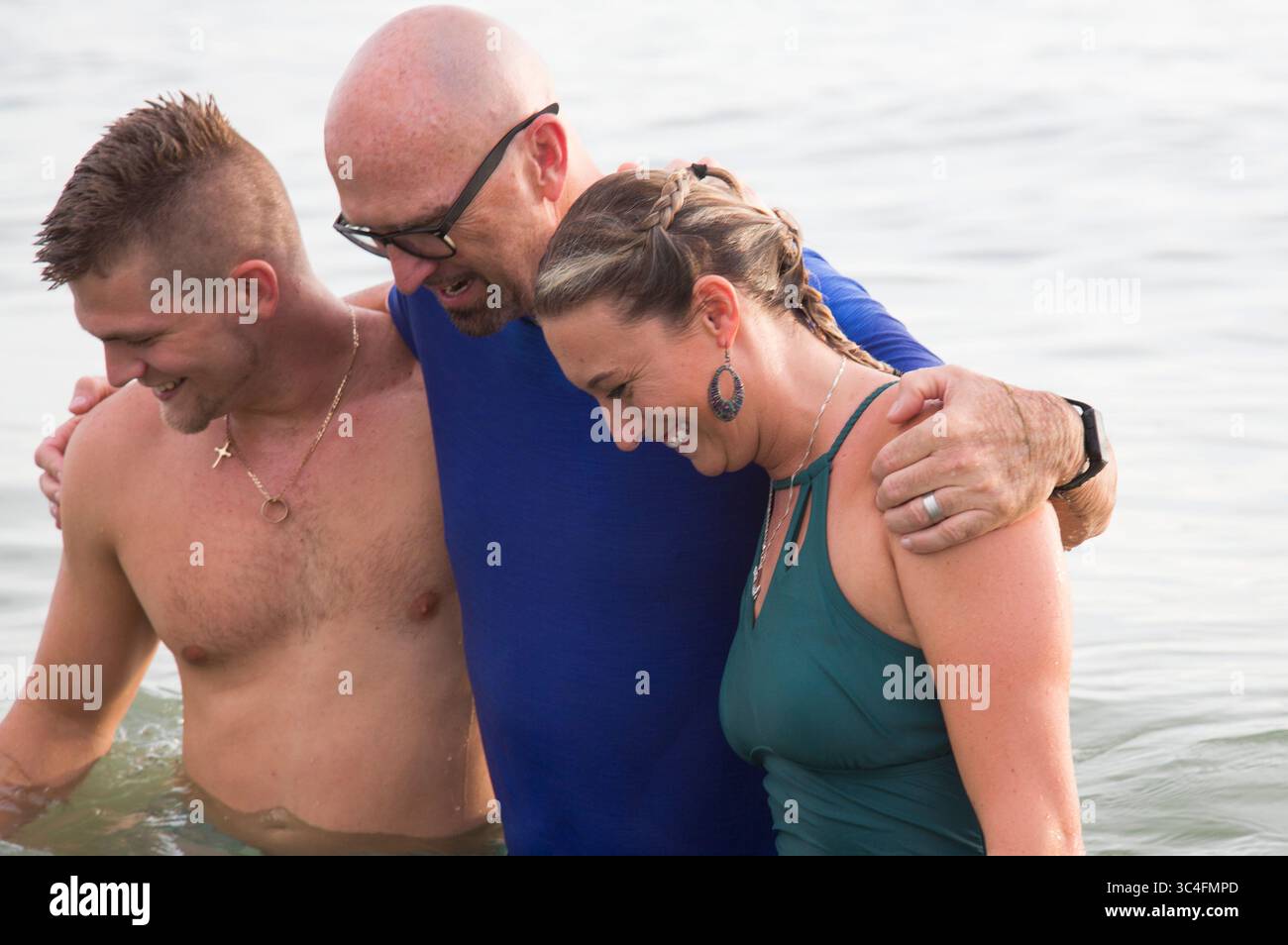 1. Juli 2018 - Florida, USA - EVE EDELHEIT | Times.Austin und Jodi Holcomb umarmen ihren Pastor Phil Lewis nach ihrer Taufe am Johns Pass in Madeira Beach am 1. Juli 2018. Ã’Manche Leute nennen die Taufe einen Eintritt in ein wässriges Grab, Ã“ sagte der Lewis. Ã’Tan youÃ•Re wurde wieder zum Leben erweckt. ThatÃ•ist deine Auferstehung. (Bild: © Eve Edelheit/Tampa Bay Times via ZUMA Wire) Stockfoto