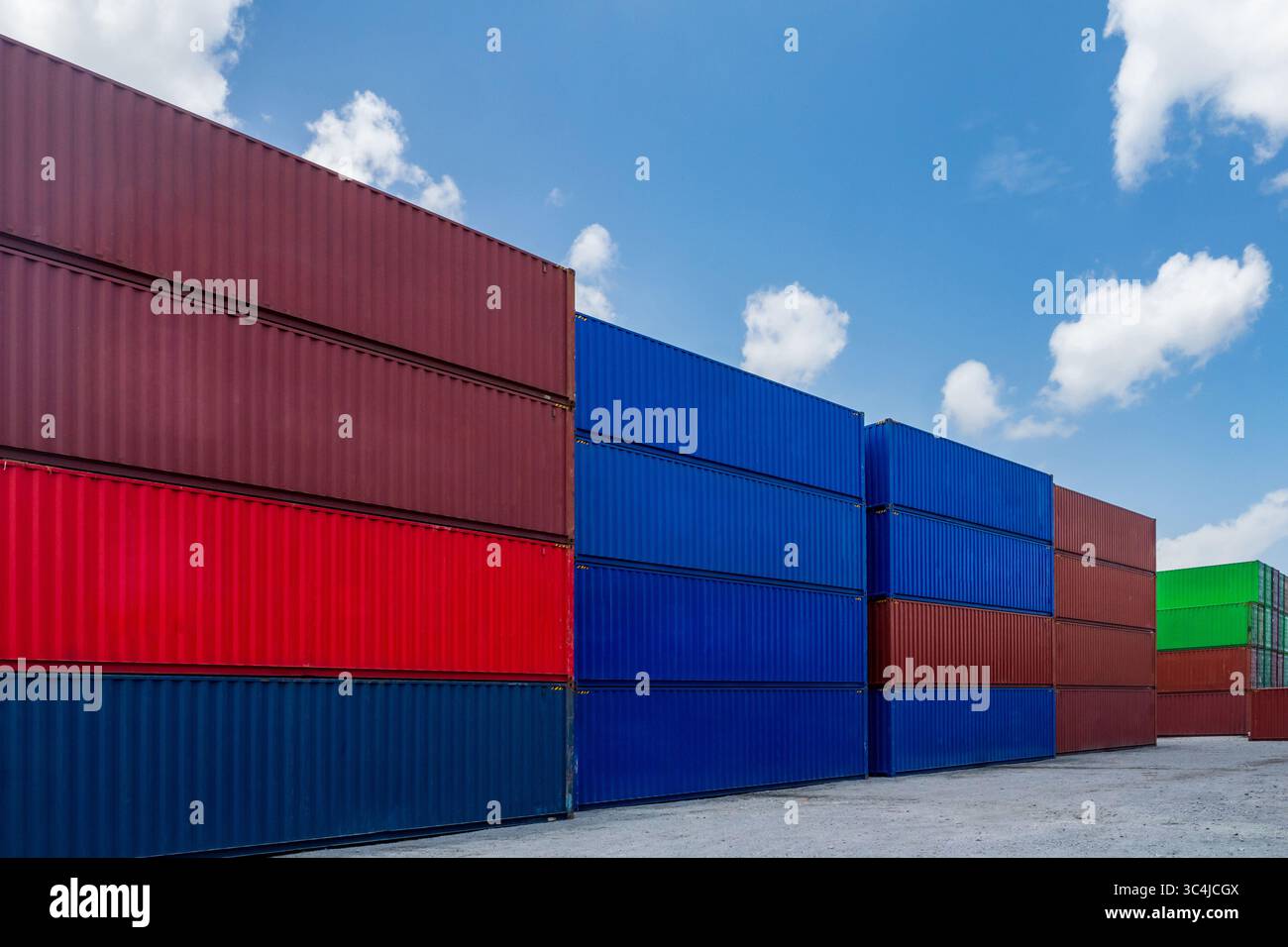 Bunte Versandfracht-Container-Stapelstapel vor blauem Himmel-Hintergrund im internationalen Industrie-Hafen-Verschiffungsterminal-Yard am Handelshafen Stockfoto