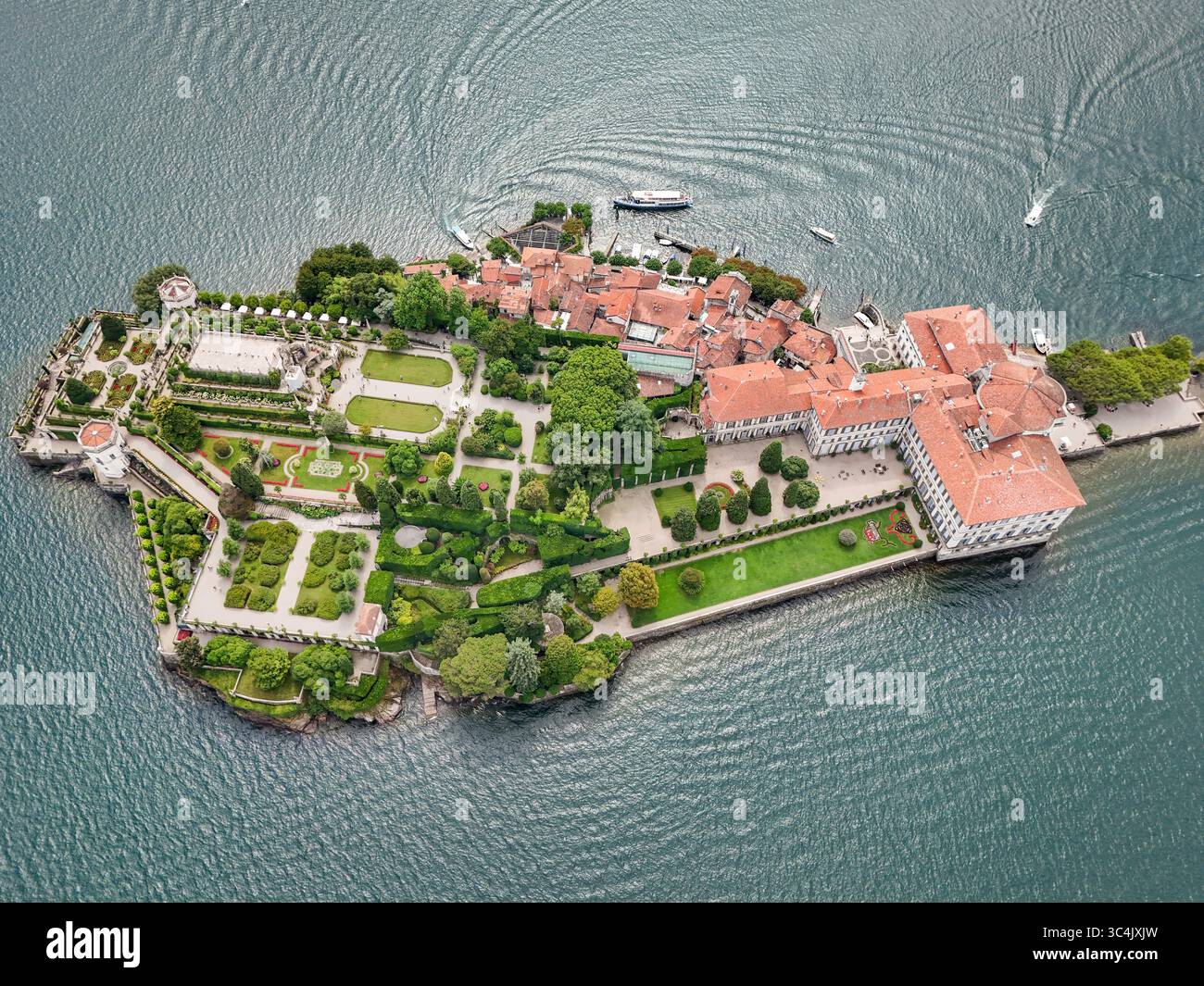 Aus der Vogelperspektive auf Isola Bella's Terrassengärten, Palast und charmantes Dorf schimmern inmitten des tiefblauen Wassers des Lago Maggiore, Italien. Stockfoto
