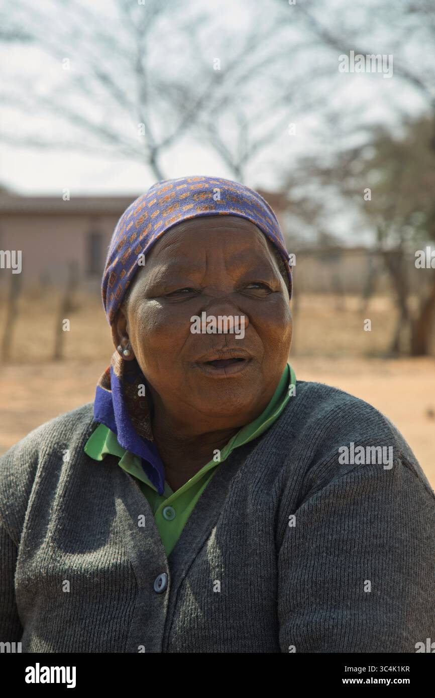 Porträt der glücklichen übergewichtigen alten afrikanerin im Dorf, Botswana ländliche Gegend, draußen im Hof, Haus im Hintergrund Stockfoto
