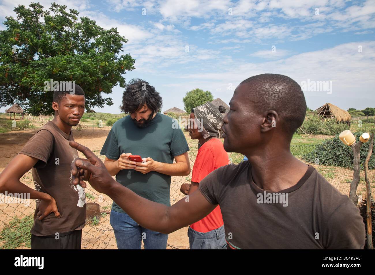 Afrikanische Dorfmenschen und Freiwillige für gemeinnützige Zwecke teilen ihr Wissen in der Smartphone-App, um das Leben in armen Regionen zu verbessern Stockfoto