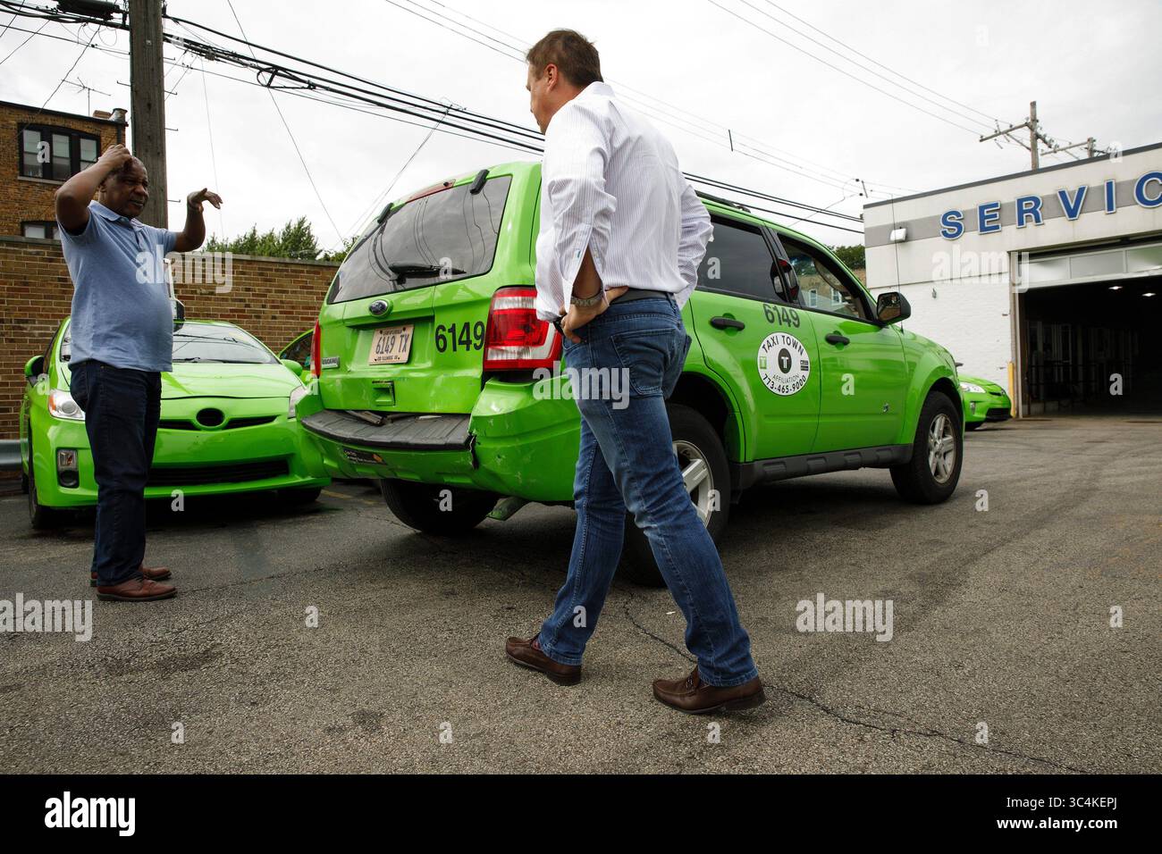 24. August 2018 - Glenview, IL, USA - Taxifahrer Mamadou Bah, links, meldet sich am 24. August 2018 auf dem Taxi Town Grundstück auf Chicagos North Side an dem Taxibesitzer Adrian Tudor. Taxi Town, ein 2-jähriges Unternehmen, hat einen Großteil seiner 370-Auto-Flotte grüner Taxis wegen sinkender Einnahmen und fehlender Fahrer im Leerlauf gelassen. (Bild: © Chris Walker/Chicago Tribune/TNS via ZUMA Wire) Stockfoto