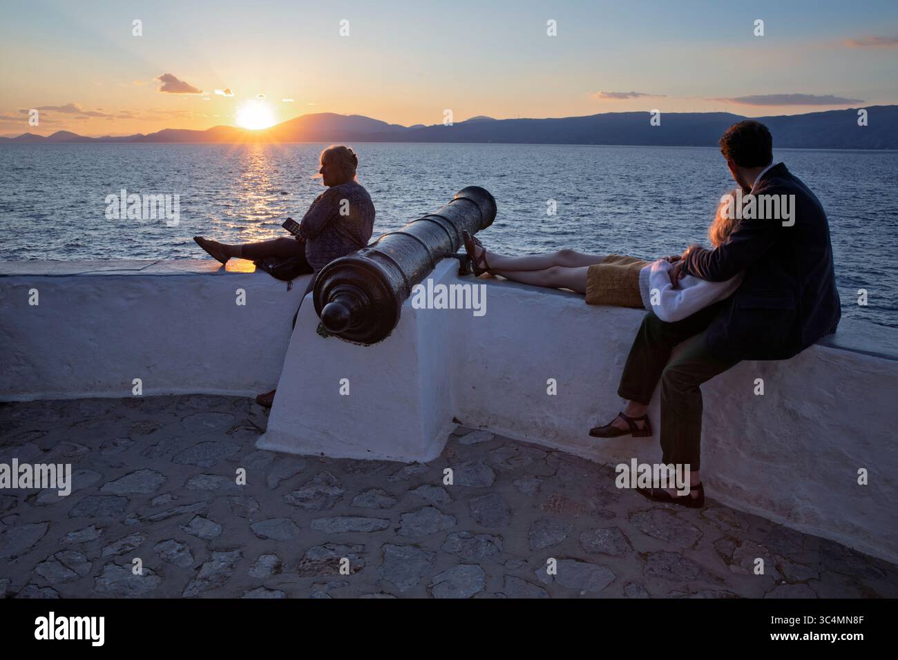 Menschen, die den Sonnenuntergang am Sonnenuntergang beobachten, Hydra, Saronische Inseln, griechische Inseln, Griechenland, Europa Stockfoto