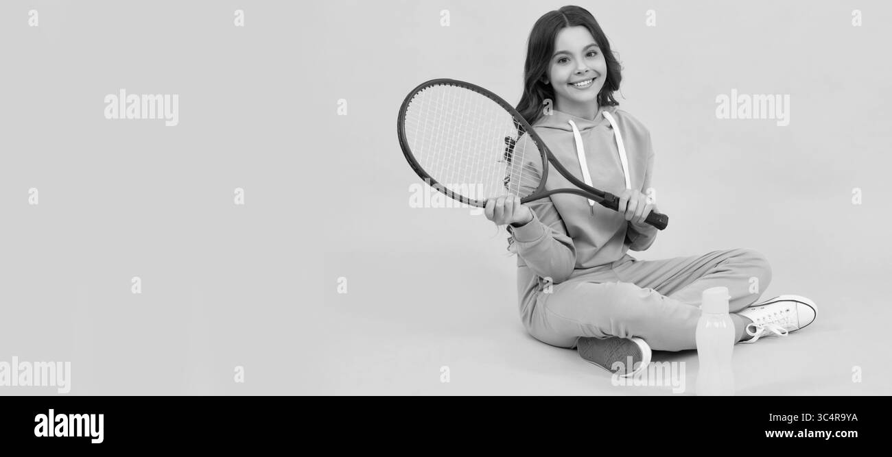 Kind sitzen mit Schläger und Wasserflasche. Kind mit Tennisschläger. Teenager-Mädchen nach dem Sporttraining. Horizontales Poster mit isoliertem Kindergesicht, Banner Stockfoto