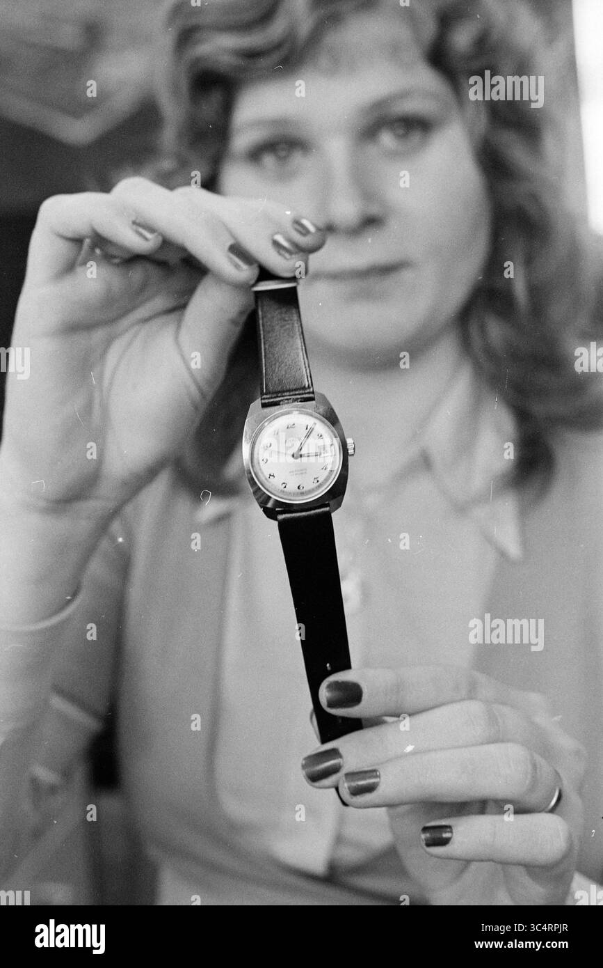 Uhren Whizgle News, Dutch Desk, Niederlande, 1950-2000 Eine Person zeigt eine Vintage-Armbanduhr, die ihr Gesicht und ihr elegantes Design betont und gleichzeitig mit gepflegten Nägeln stilvoll zeigt. Stockfoto