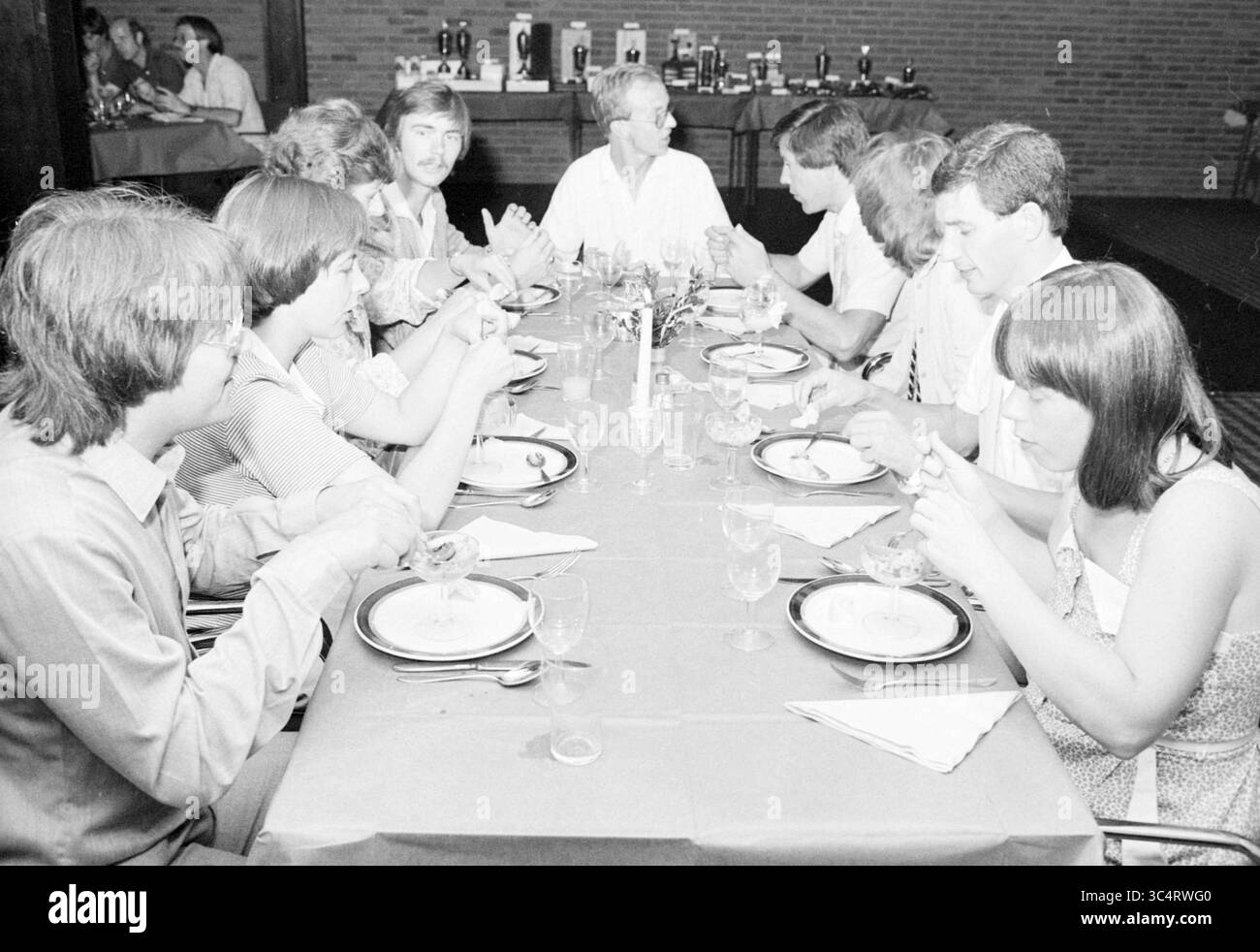Tennis. Abendessen und Preisverleihung, 00-00-1981 Whizgle News, Dutch Desk, Niederlande, 1950-2000 Eine Gruppe von Menschen versammelt sich an einem langen Tisch, um sich zu unterhalten und eine Mahlzeit zu genießen. Die Atmosphäre wirkt lebhaft, mit Tellern und Gläsern zum Abendessen, und ein paar Personen nehmen aktiv an Diskussionen Teil. Stilvolle Kleidung ist ein formeller oder besonderer Anlass. Stockfoto