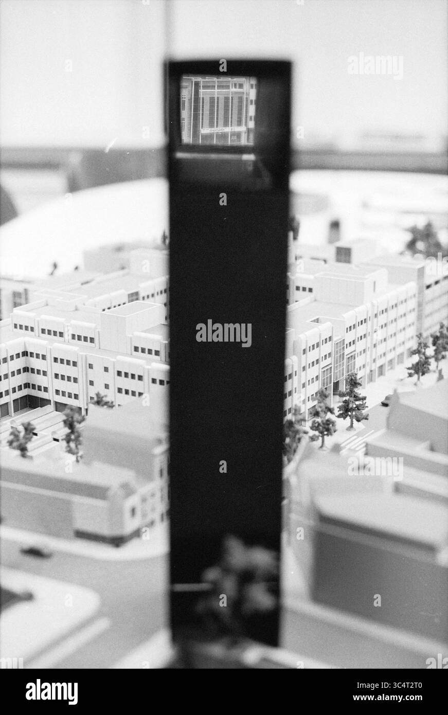 Modell fa. Jonk de Rooij, 08-01-1992 Whizgle News, Dutch Desk, Niederlande, 1950-2000 Ein detailliertes Architekturmodell zeigt eine Stadtlandschaft mit verschiedenen Gebäuden, Straßen und Grünflächen. Im Vordergrund spiegelt eine hohe vertikale Struktur ein zeitgenössisches Design wider, was auf seine Bedeutung innerhalb des Stadtbildes hindeutet. Stockfoto