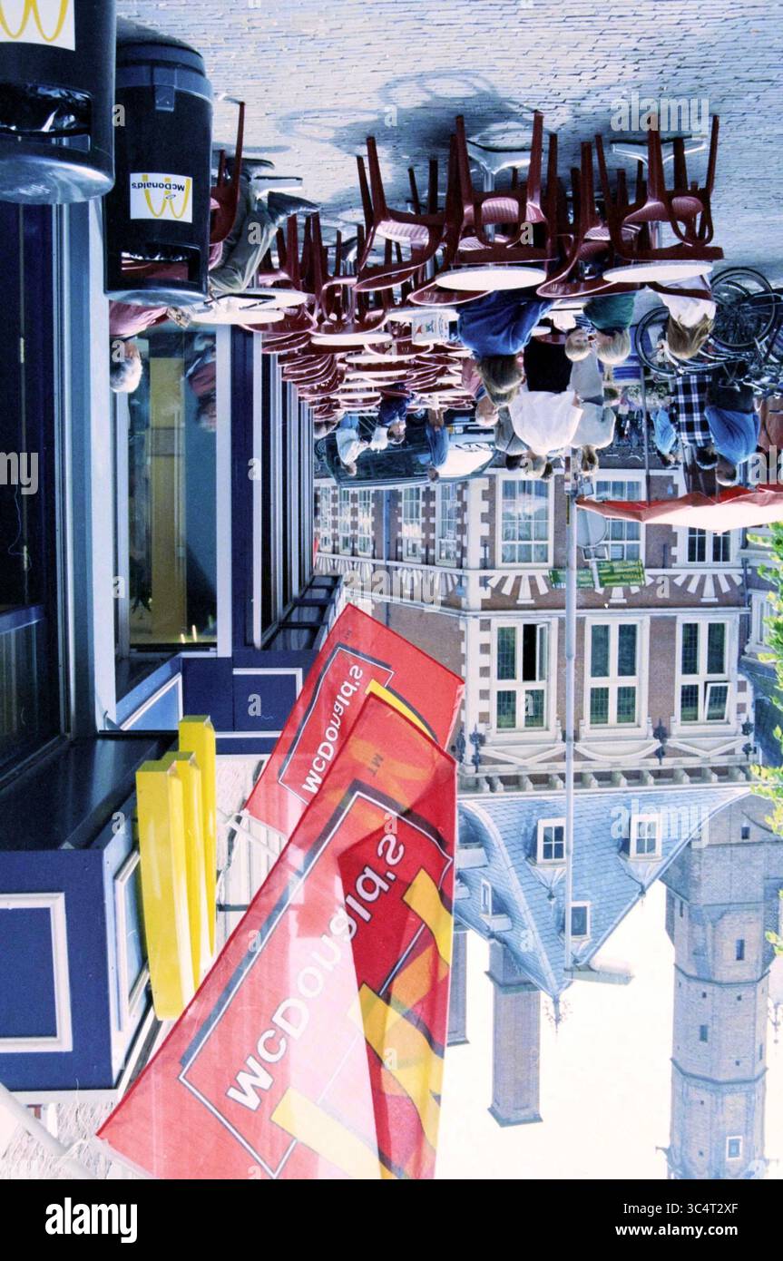 Illegale Terrasse McDonalds Grote Markt, Haarlem, Grote Markt, Niederlande, 25-05-1997 Whizgle News, Dutch Desk, Niederlande, 1950-2000 Eine lebhafte Straßenszene mit Sitzgelegenheiten im Freien vor einem Restaurant, in dem Gäste ihre Zeit genießen. Farbenfrohe Beschilderungen verleihen dem Ambiente Lebendigkeit, während nahe gelegene Gebäude eine bezaubernde Kulisse bieten. Stockfoto