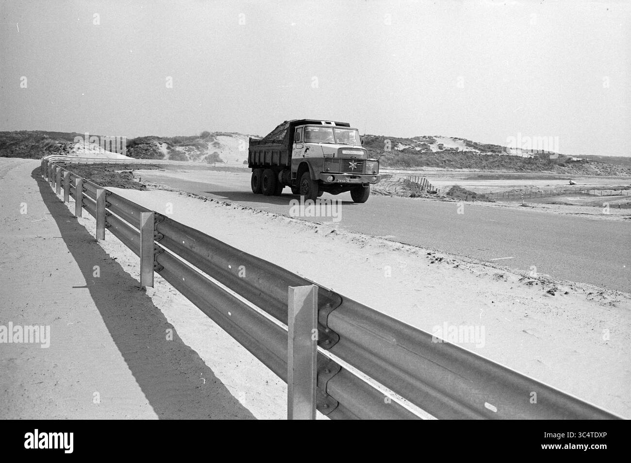 Works Circuit Zandvoort, Works, 25-04-1973 Whizgle News, Dutch Desk, Niederlande, 1950-2000 Ein großer Lkw fährt entlang einer kurvenreichen Straße neben einer sandigen Landschaft mit sandigen Dünen im Hintergrund und einer Metallgeländer entlang der Straße. Stockfoto