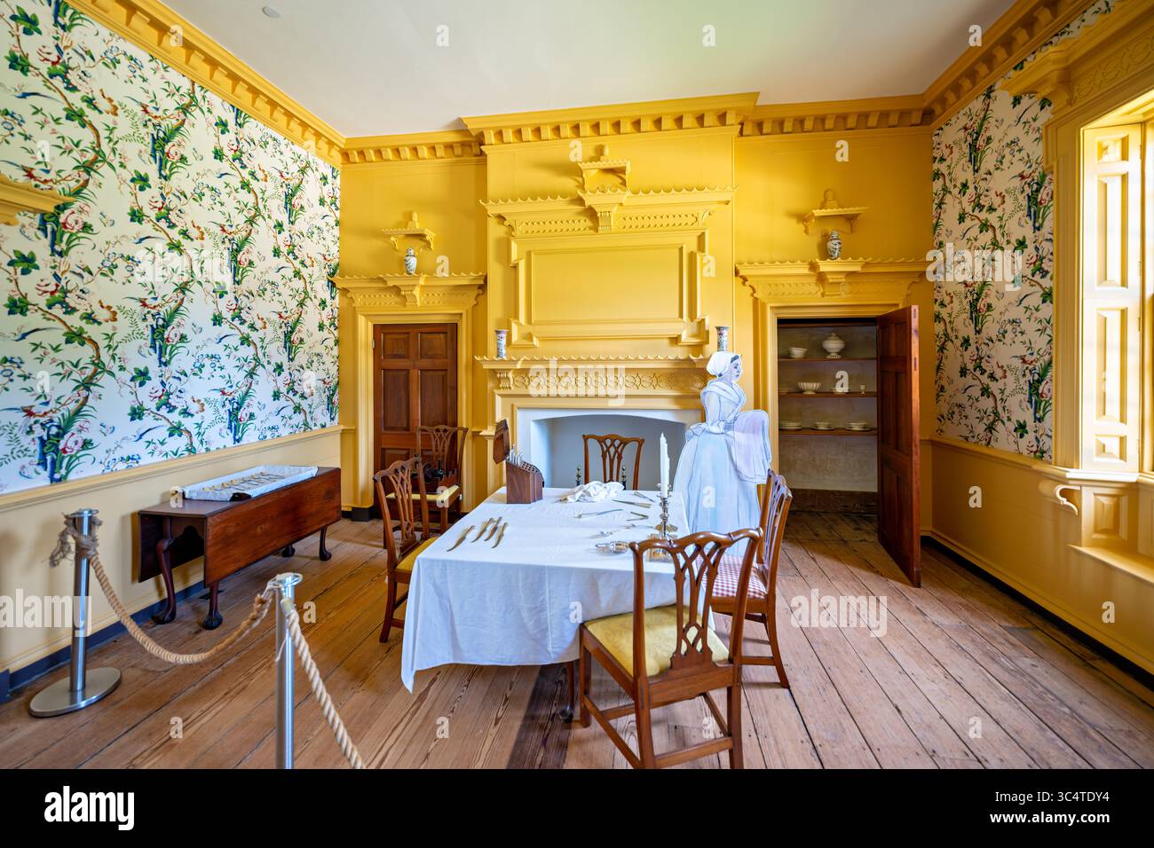 LORTON, Virginia – der West Dining Room der Gunston Hall von George Mason, auch bekannt als Chinese Room, zeigt die einzige bekannte, koordinierte Chinoiserie-Holzarbeit im Kolonialamerika, die unter der Aufsicht des englischen Architekten William Buckland zwischen 1755 und 1759 entstand. Der Raum ist mit pagodenartigen Stuckverzierungen, Kiefernzapfen auf den Vordächern, komplizierten Griffarbeiten und gelben ockerfarbenen Wandfarben ausgestattet, die die Besucher des 18. Jahrhunderts verzaubert hätten. Dieser raffinierte Speisesaal diente George Mason IV (1725–1792), dem Hauptautor der Virginia Declaration of Rights, und repräsentiert die h Stockfoto