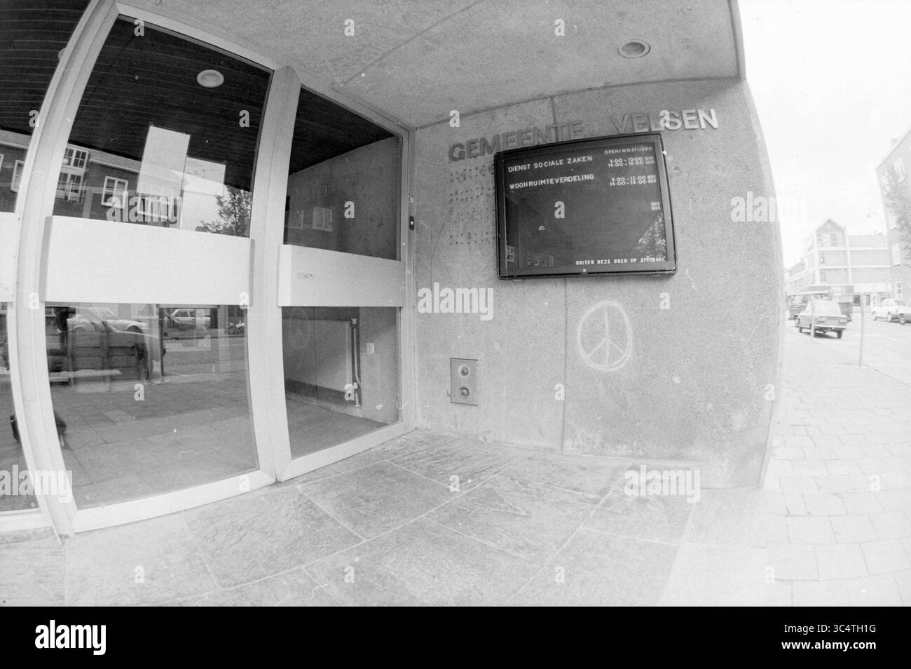Eingang Soc Service, IJmuiden, Sozialarbeit, IJmuiden, Niederlande, 04-08-1986 Whizgle News, Dutch Desk, Niederlande, 1950-2000 der Eingang zu einem Gemeindegebäude verfügt über eine große digitale Anzeigetafel, auf der die Veranstaltungszeiten und -Ankündigungen aufgeführt sind, während die glatte, moderne Fassade Glastüren und ein in den Stein eingeätztes Friedenssymbol enthält. Stockfoto