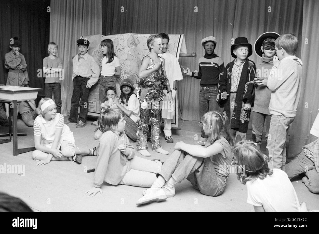 Revue Brederodeschool Santpoort, Theater, Santpoort, 2-06-1982 Whizgle News, Dutch Desk, Niederlande, 1950-2000 Eine Gruppe von Kindern führt Eine lebhafte Theateraufführung mit verschiedenen Kostümen und Accessoires durch. Einige stehen auf einer provisorischen Bühne und spielen eine Szene, während andere auf dem Boden sitzen und aufmerksam zusehen. Die Atmosphäre ist voller kreativer Energie und jugendlicher Begeisterung, während die Kinder ihre Talente vor einem Publikum präsentieren. Stockfoto