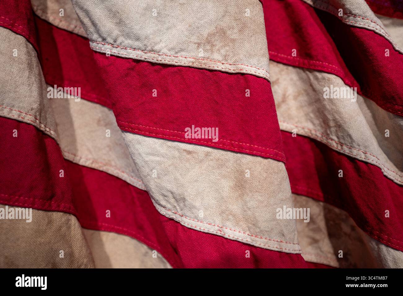 VEREINIGTE STAATEN – Eine detaillierte Ansicht einer Reproduktion der Flagge aus der Zeit des Unabhängigkeitskriegs mit den markanten roten und weißen Streifen, die die amerikanischen Kolonien symbolisierten. Diese Flaggenart mit ihren abwechselnden roten und weißen horizontalen Streifen gehörte zu den frühesten Mustern, die während der Amerikanischen Revolution (1775–1783) verwendet wurden. Die Reproduktion fängt die historischen Textilmuster und die Färbung der Flaggen aus der Zeit ein, als die Vereinigten Staaten für die Unabhängigkeit von Großbritannien kämpften. Stockfoto