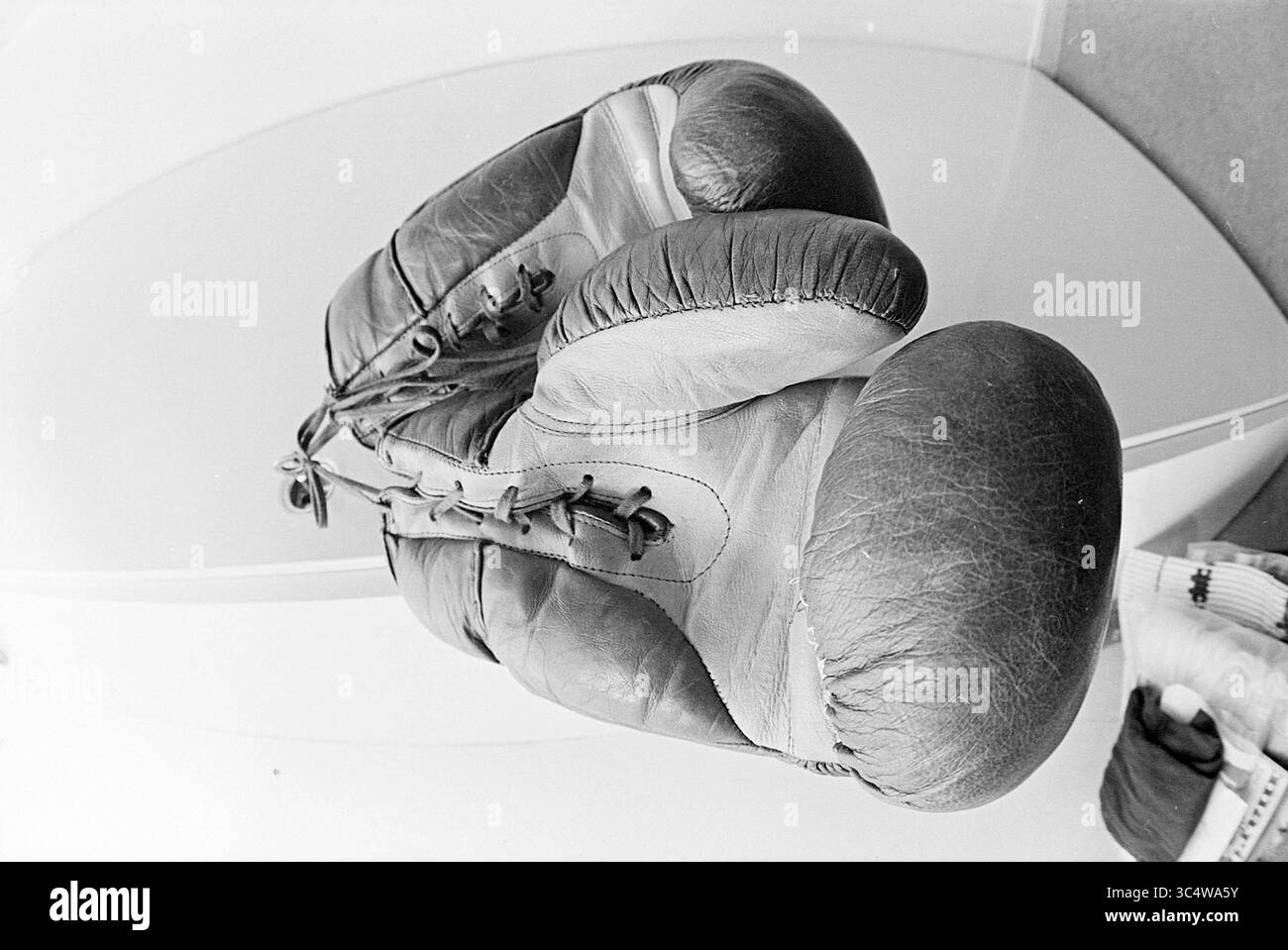 Vorsitzender des Boxverbandes, den Haag, Boxen, Personen, 27-01-1971 Whizgle News, Dutch Desk, Niederlande, 1950-2000 Ein gut getragenes Paar Boxhandschuhe sitzt auf einer flachen Oberfläche und zeigt ihr verwittertes Leder und ihre komplizierte Schnürung, was auf unzählige Runden im Ring hindeutet. Stockfoto
