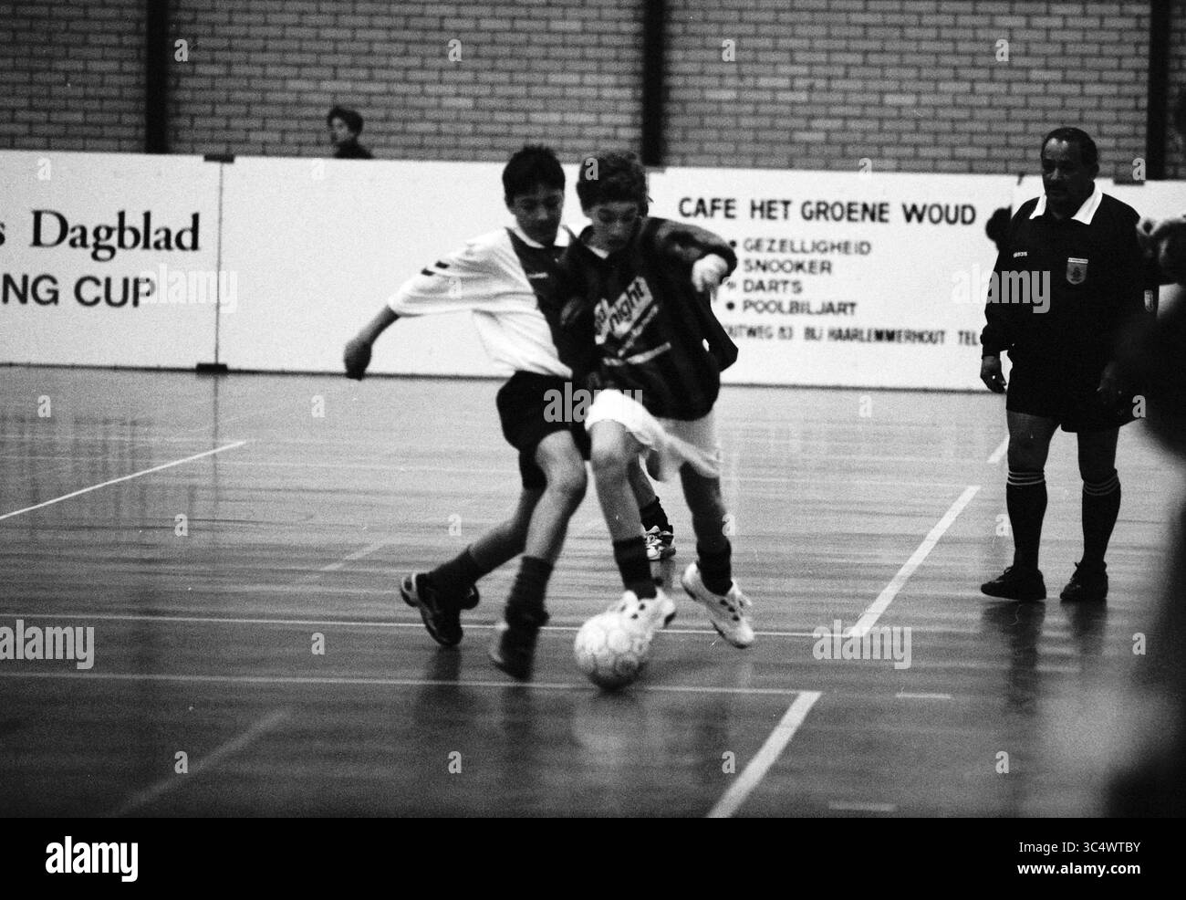 Fußball: Boarding Cup RCH - DCO, Haarlem, Niederlande, 29-12-1997 Whizgle News, Dutch Desk, Niederlande, 1950-2000 zwei junge Fußballspieler kämpfen während eines Hallenspiels heftig um den Ball, während ein Schiedsrichter die Aktion genau beobachtet. Ihre Uniformen zeigen ihr Engagement für das Spiel, und die Begeisterung des Sports ist in der Intensität ihrer Bewegungen spürbar. Stockfoto