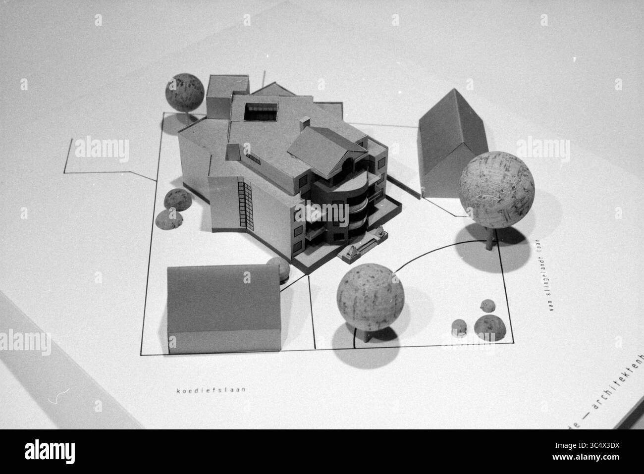 Modell des Architekturbüros Koster, Wohnhaus Koediefslaan, Van Slingelandtlaan, Heemstede, Niederlande, 27-05-1991 Whizgle News, Dutch Desk, Niederlande, 1950-2000 Ein Modell eines modernen architektonischen Entwurfs mit einer mehrstöckigen Struktur mit geschwungenen Elementen, umgeben von geometrischen Formen, die Bäume und kleinere Gebäude darstellen. Das Layout betont die Beziehung zwischen dem Hauptgebäude und seiner Landschaft. Stockfoto