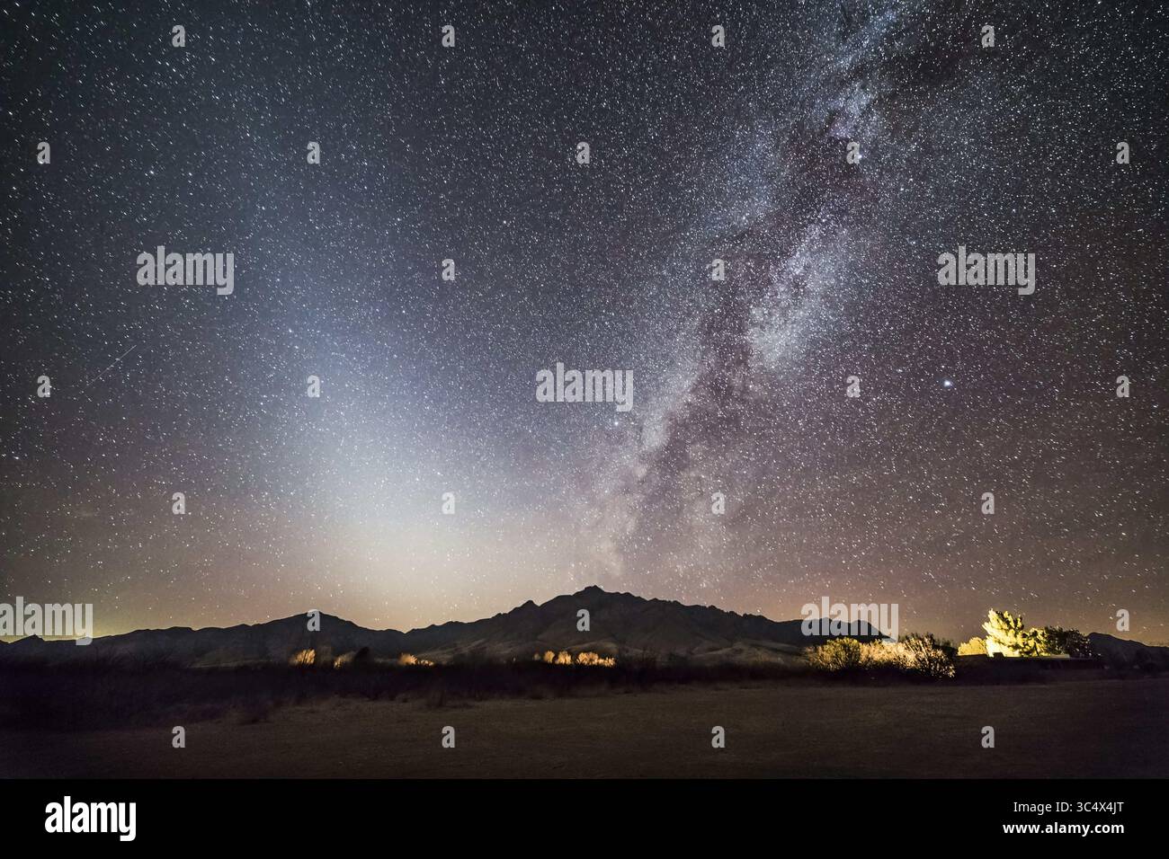 14. Dezember 2017 - Arizona, USA - Darstellungen von zwei Arten von Staub im Weltraum: Links das pyramidenförmige Leuchten des Zodiakallichts, das durch Sonnenlicht hervorgerufen wird, das den interplanetaren Staub im inneren Sonnensystem von Kometen und Meteoroiden reflektiert, während rechts das Band der hellen Milchstraße aus Sternen in unserer Galaxie ist. Aber entlang liegen dunkle Bahnen aus interstellarem Staub, der aus Kohlenstoffverbindungen besteht, die in den Atmosphären von Sternen hergestellt und in die Galaxie verstreut sind. ..das ist vom Quailway Cottage in der Nähe von Portal, Arizona, am 14. Dezember 2017, mit Blick nach Westen zu den Chiricahua Mountains im Südosten von AR Stockfoto