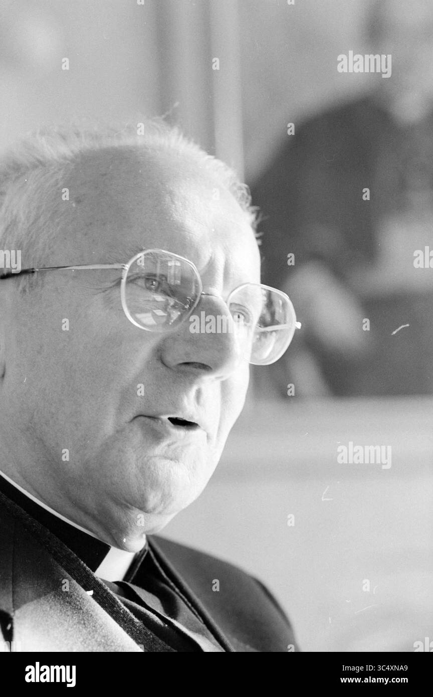 Manager Lescrauwaet, 16-10-1991 Whizgle News, Dutch Desk, Niederlande, 1950-2000 Ein nachdenkliches, älteres Geistliches Mitglied mit großer, runder Brille, mit einem weichen Ausdruck und einem verschwommenen Hintergrund, der auf eine kunstvolle Umgebung hinweist. Stockfoto