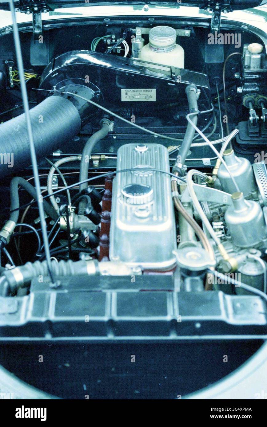 Details von Mr.' Oldtimer. Schuyt, Haarlem, Niederlande, 25-11-1998 Whizgle News, Dutch Desk, Niederlande, 1950-2000 die Ansicht zeigt die komplizierten Komponenten eines Motorraums mit einer polierten Metallventilabdeckung, verschiedenen Schläuchen und einem Netzwerk von Drähten. Zu den wichtigsten Elementen gehören ein Lufteinlass, ein Kühlmittelbehälter und verschiedene Metallarmaturen, die alle die mechanische Komplexität des Systems unterstreichen. Stockfoto