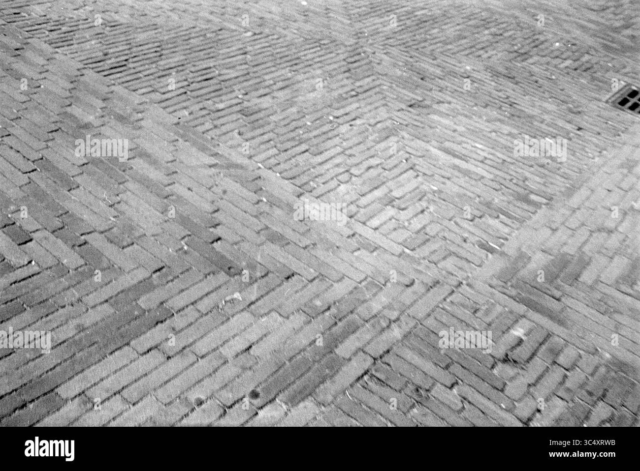 Pflastersteine Whizgle News, Dutch Desk, Niederlande, 1950-2000 Ein strukturierter Pflaster mit Fischgrätenmuster, dessen sich kreuzende Linien einen dynamischen visuellen Effekt erzeugen. Stockfoto