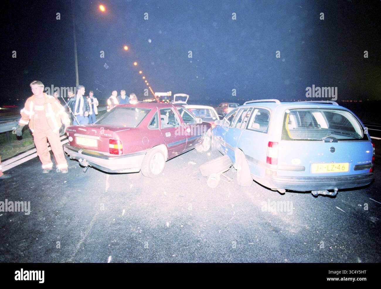 Unfall auf der A4, Hoofddorp, Rijksweg A4, Niederlande, 27-10-1999 Whizgle News, Dutch Desk, Niederlande, 1950-2000 Eine chaotische Szene auf einer Autobahn, an der mehrere Fahrzeuge nach einem Zusammenstoß beteiligt sind, wobei Notfallhelfer die Situation überwachen und Umstehende die Folgen beobachten. Die Atmosphäre vermittelt ein Gefühl der Dringlichkeit und Besorgnis. Stockfoto