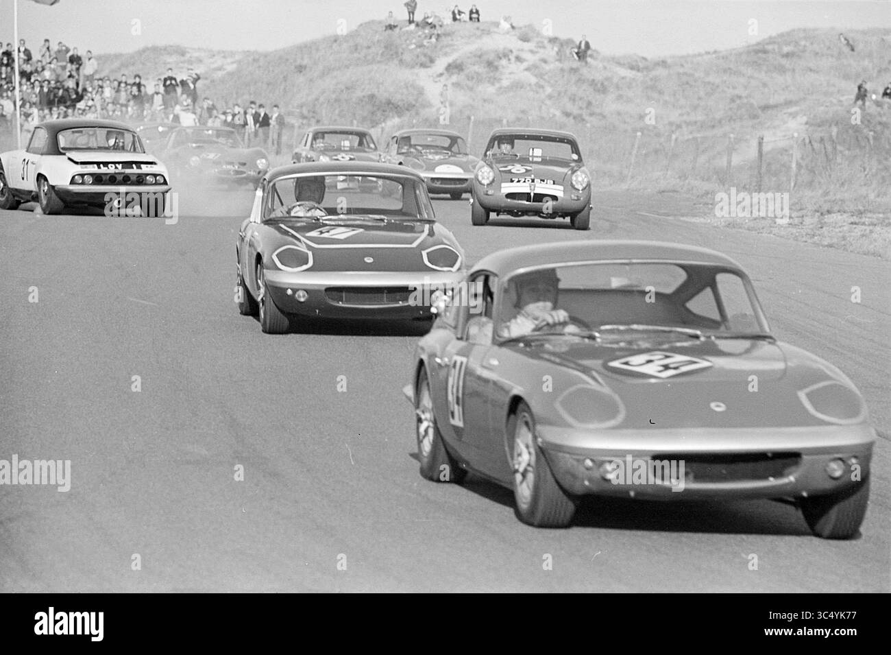 Autorennstrecke Zandvoort, Zandvoort, Whizgle News, Dutch Desk, Niederlande, 1950-2000 Eine aufregende Rennszene, in der klassische Sportwagen auf einer kurvenreichen Strecke fahren, Zuschauer im Hintergrund und Staub aus den Reifen steigen, während die Teilnehmer in Richtung Ziellinie rasen. Stockfoto