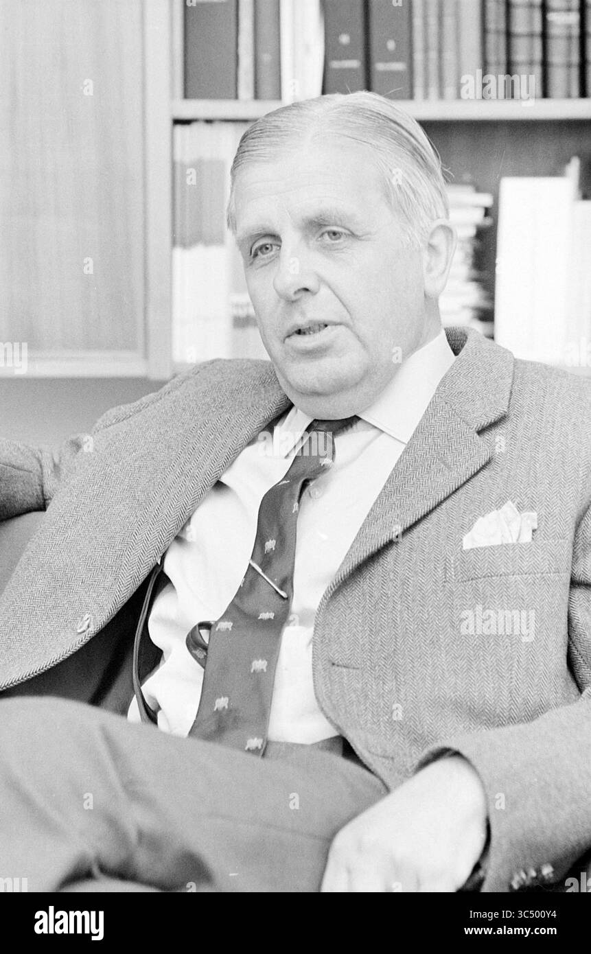 Bürgermeister von Hoofddorp, Personen, 25-05-1967 Whizgle News, Dutch Desk, Niederlande, 1950-2000 Ein Mann mit durchdachtem Ausdruck sitzt in einem maßgeschneiderten Anzug mit gemusterter Krawatte und einem Taschenquadrat. Er scheint in Gesprächen verwickelt zu sein, umgeben von Bücherregalen. Stockfoto
