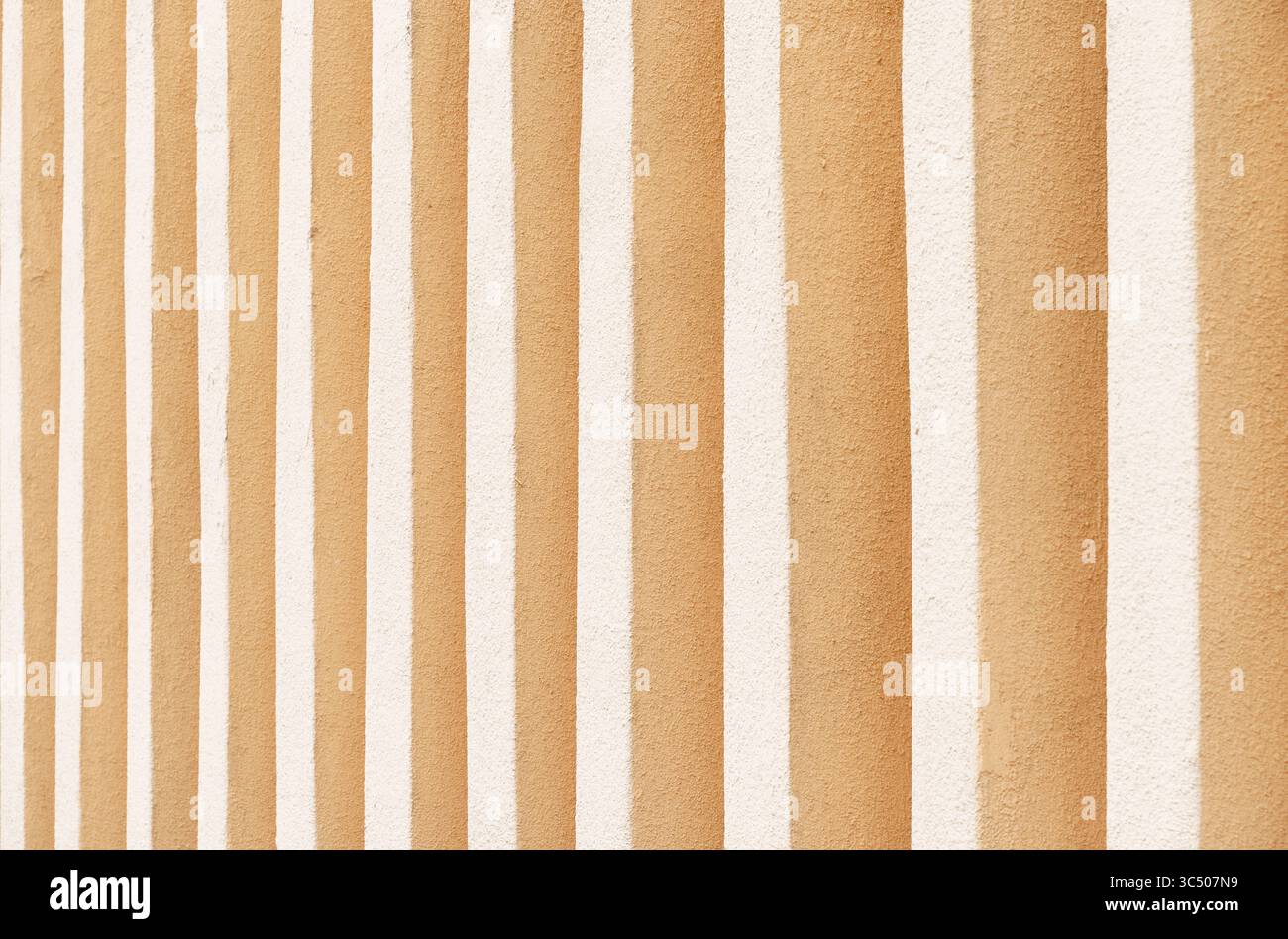 Eine atemberaubende Darstellung von abwechselnden orangefarbenen und weißen Streifen schafft eine einzigartige Textur auf einer rustikalen Wand. Die warmen Töne wecken ein Gefühl von Wärme und Chara Stockfoto