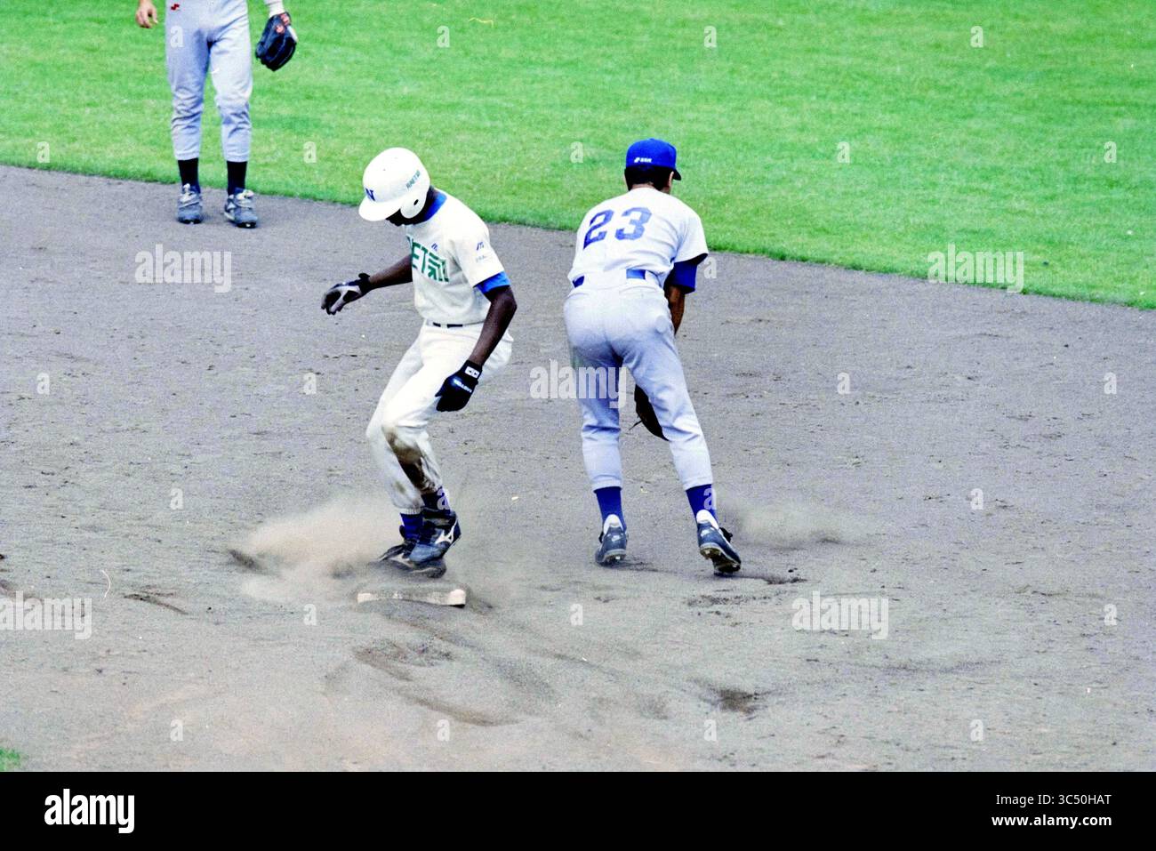 Baseballspiel Niederlande - Italien Whizgle News, Dutch Desk, Niederlande, 1950-2000 Ein Baseballspieler rutscht in die Basis und wirft Staub auf, während ein gegnerischer Spieler bereit ist, ihn zu markieren. Stockfoto