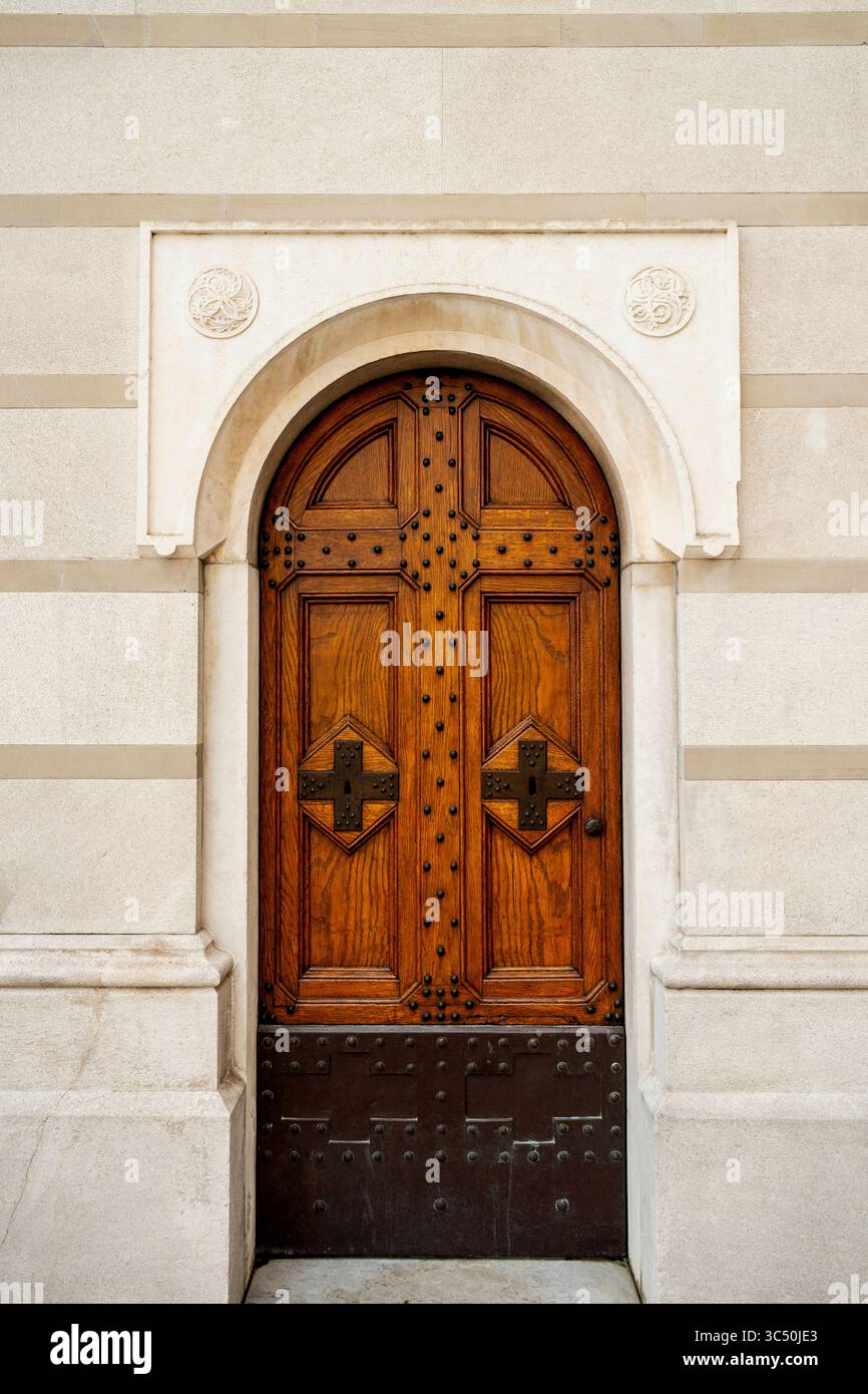 Hölzerne Seitentür der neobyzantinischen serbisch-orthodoxen Kirche St. Spyridon in Triest, Italien. Stockfoto