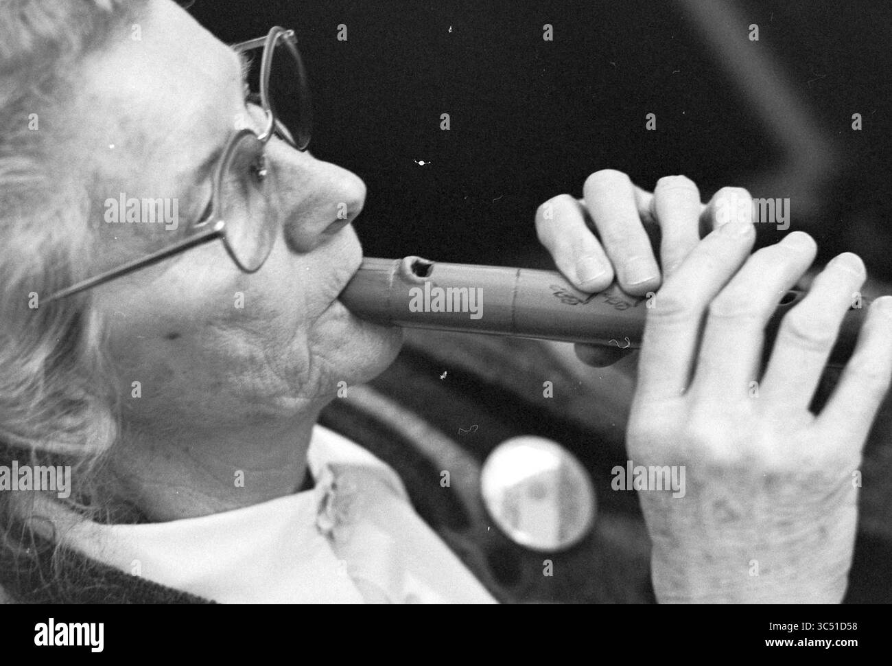 Mrs. Huisman über Flötenkonzert, 06-05-1993 Whizgle News, Dutch Desk, Niederlande, 1950-2000 eine ältere Frau spielt eine Holzflöte, ihre Augen konzentriert und einen sanften Gesichtsausdruck, der ihre Verbindung zur Musik und ihre Leidenschaft für die Kunst zum Ausdruck bringt. Stockfoto