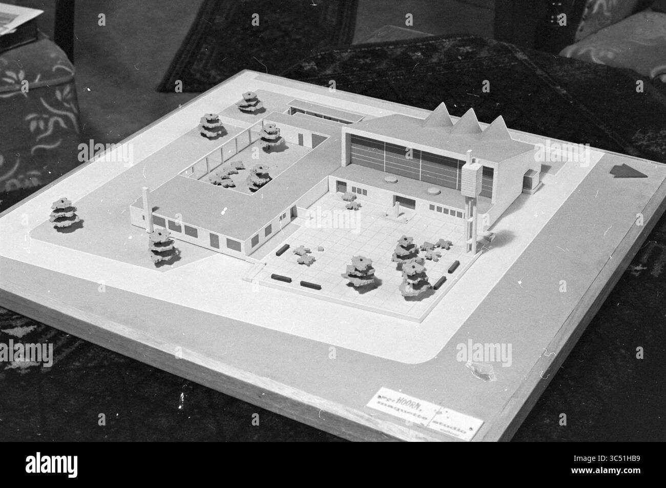 Model RC Redeemer Church, Boerhaavewijk, Haarlem, Niederlande, 16-12-1964 Whizgle News, Dutch Desk, Niederlande, 1950-2000 Ein detailliertes architektonisches Modell, das einen modernen Gebäudekomplex mit Landschaftsgärten, Parkplätzen und charakteristischen Dachlinien präsentiert, die alle auf einer Basis mit beschrifteten Elementen präsentiert werden. Stockfoto