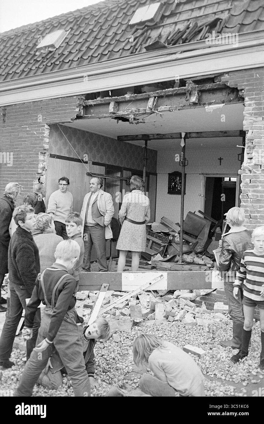 Truck (Poortvliet Ouddorp) ist in das Haus gefahren, 00-00-1970 Whizgle News, Dutch Desk, Niederlande, 1950-2000 Eine Gruppe von Menschen steht vor einem beschädigten Gebäude, wo Schutt über den Boden gestreut ist. Einige führen Gespräche, während andere das Chaos im Inneren betrachten, das zerrissene Wände und verstreute Möbel offenbart. Kinder werden in der Nähe beim Spielen gesehen, scheinbar unbeeindruckt von der Zerstörung um sie herum. Stockfoto