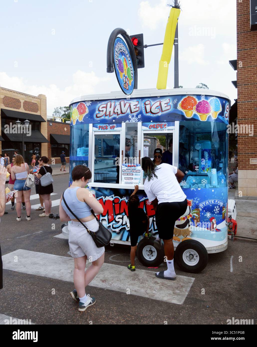Eltern und Kind bestellen rasierte Eiskegel. Ich sehe, dass das Motto lautet: Genau wie im Paradies. Großartiger Spaziergang im alten Tag. St. Paul Minnesota MN USA Stockfoto