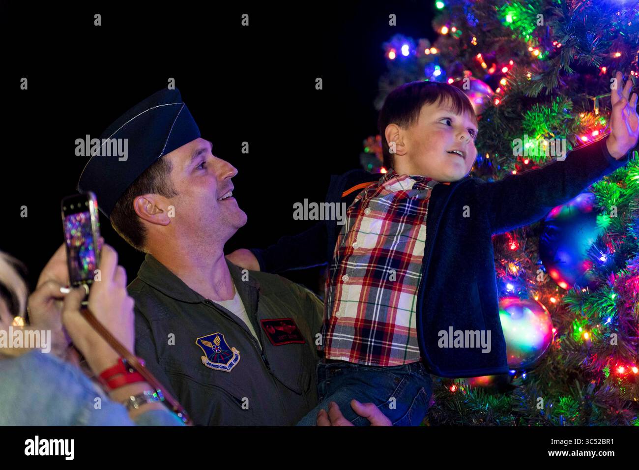 4. Dezember 2019: Barksdale Air Force Base, Louisiana, USA – Lieutenant Col. Matt Baker, Kommandant der 96th Bomb Squadron, hält seinen Sohn vor einem Weihnachtsbaum auf der Barksdale Air Force Base, La, 4. Dezember 2019. Familien aus ganz Barksdale versammelten sich, um den Baum zum ersten Mal in diesem Jahr zu beobachten. (Bild: © U.S. Air Force/ZUMA Wire/ZUMAPRESS.com) Stockfoto