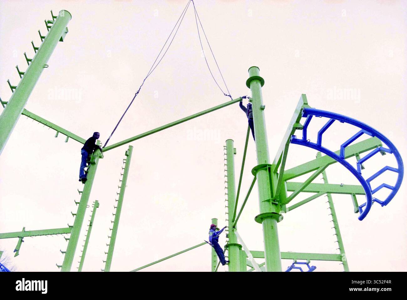 Bau einer Messe auf Zaanenlaan, Haarlem, Zaanenlaan, Niederlande, 22-04-2001 Whizgle News, Dutch Desk, Niederlande, 1950-2000 Arbeiter werden beobachtet, wie sie eine große, farbenfrohe Struktur mit hohen Stangen und geschwungenen Elementen zusammenbauen, die ein Bauprojekt zeigt, das verspieltes, modernes Design beinhaltet. Stockfoto