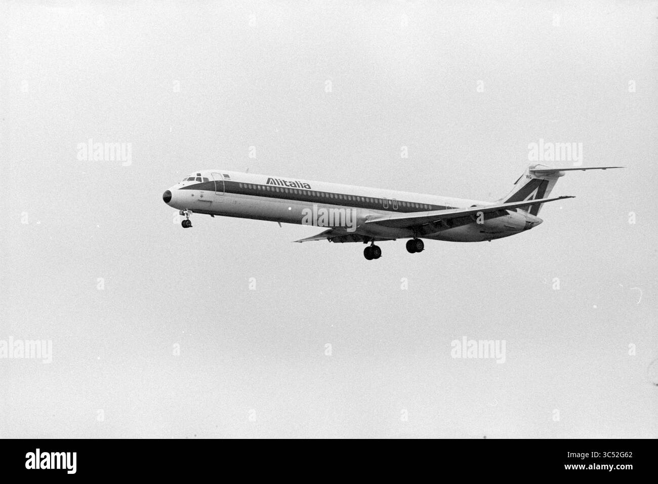 Mehrere Landungsflugzeuge, 01-04-1993 Whizgle News, Dutch Desk, Niederlande, 1950-2000 ein Alitalia-Flugzeug nähert sich zur Landung an und zeigt seine unverwechselbare Lackierung, während es vor bewölkter Kulisse fliegt. Stockfoto