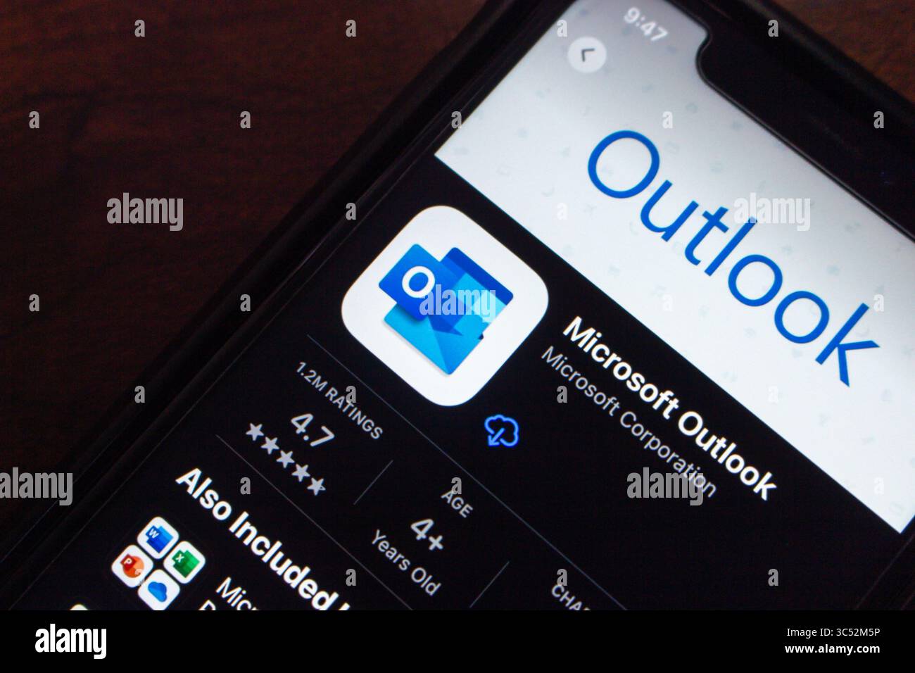 Nahaufnahme eines Smartphones, das die Microsoft Outlook-App in einem App-Store mit Bewertungen, Symbol und Installationsschaltfläche anzeigt. Stockfoto