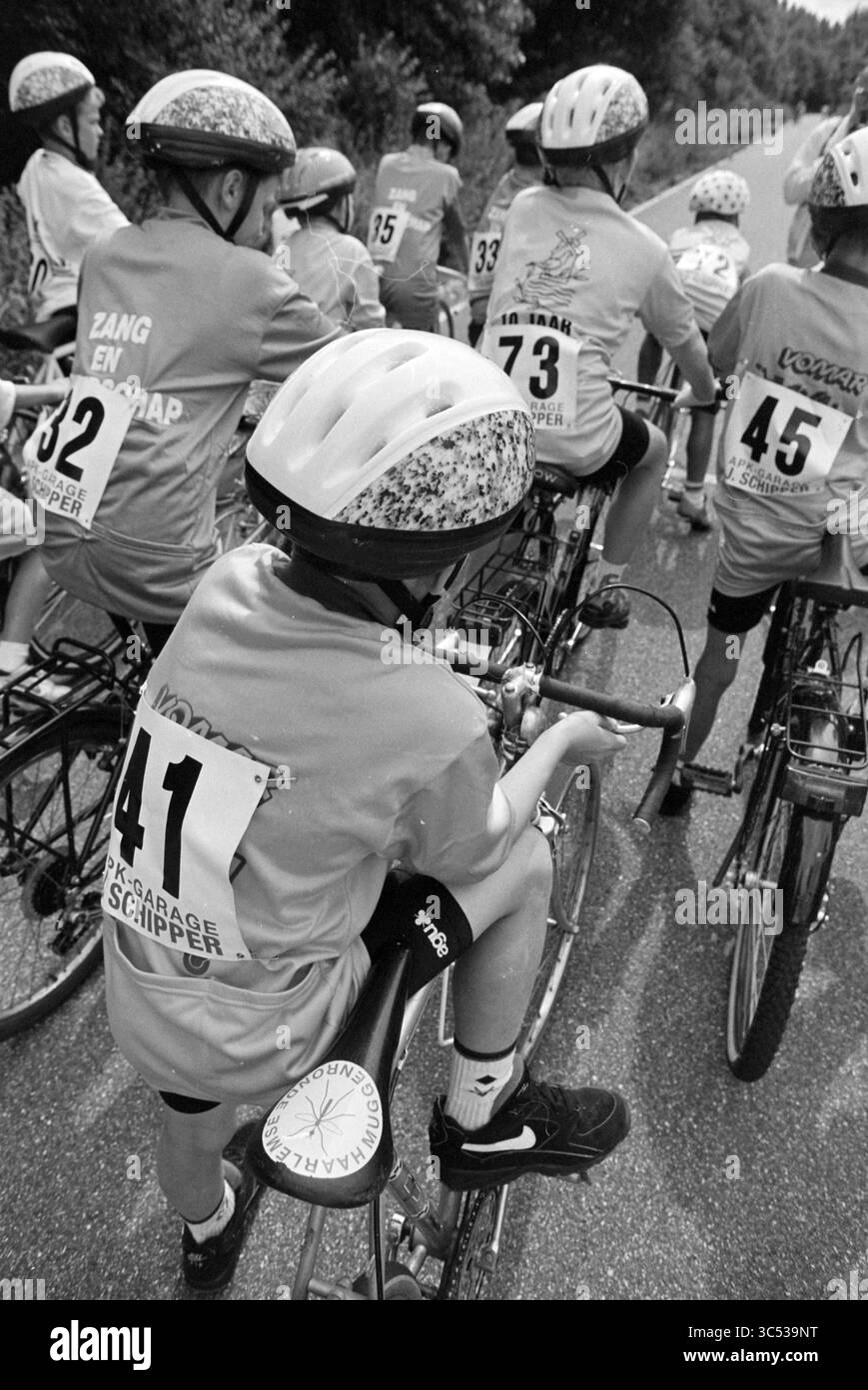 Mücke rund, Sp'woude, Spaarnwoude, 14-08-1994 Whizgle News, Dutch Desk, Niederlande, 1950-2000 Eine Gruppe junger Radfahrer, die passende Trikots und Helme tragen, versammeln sich am Straßenrand, um sich auf ihr Radabenteuer zu begeben. Jeder Fahrer zeigt eine einzigartige Nummer auf dem Rücken, die den Geist der Teamarbeit und des Wettkampfs zum Ausdruck bringt. Stockfoto