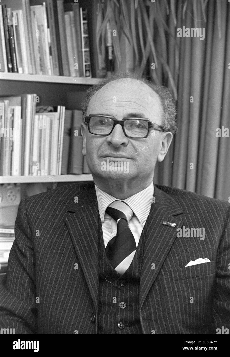 Porträt Mr. Van der Waal Heemstede - Planungsdienst, Porträts, Porträts, 15-04-1975 Whizgle News, Dutch Desk, Niederlande, 1950-2000 Ein angesehener Gentleman mit Brille sitzt, trägt einen Nadelstreifenanzug und eine gemusterte Krawatte. Er verströmt einen Hauch von Intelligenz und Besinnung, wobei im Hintergrund Regale mit Büchern sichtbar sind, was auf eine wissenschaftliche Umgebung hindeutet. Stockfoto