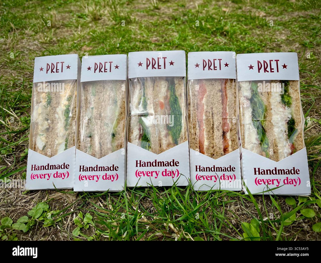 Fünf verpackte Sandwiches von Pret A Manger on the Gras, Konzept für eine preiswerte Mahlzeit auf Reisen mit der Familie - Smartphone-aufgenommenes Stockfoto